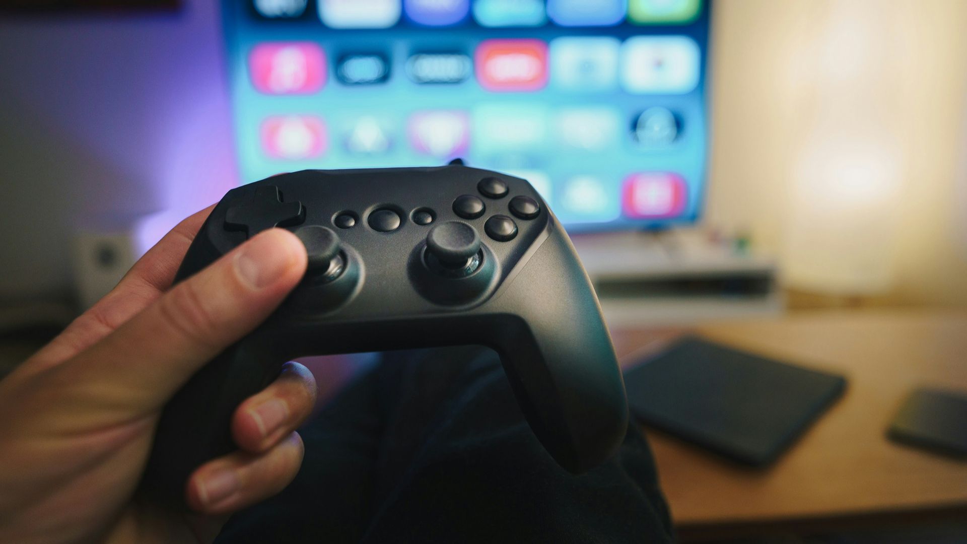 A person holding a video game controller in front of a computer