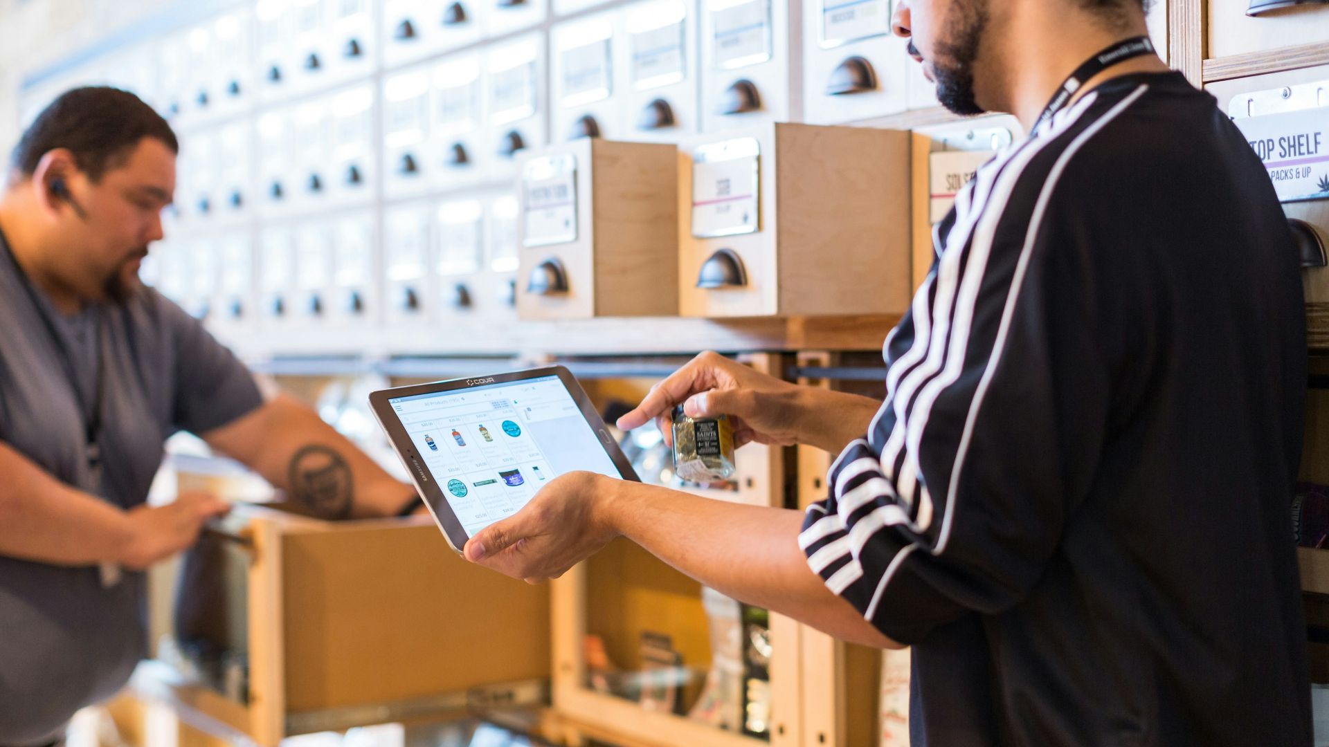 two men in a store looking at a tablet
