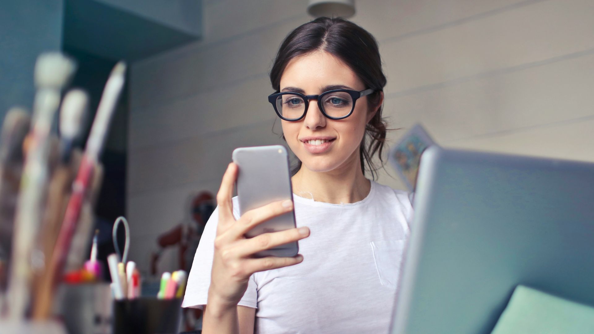 woman in white shirt using smartphone