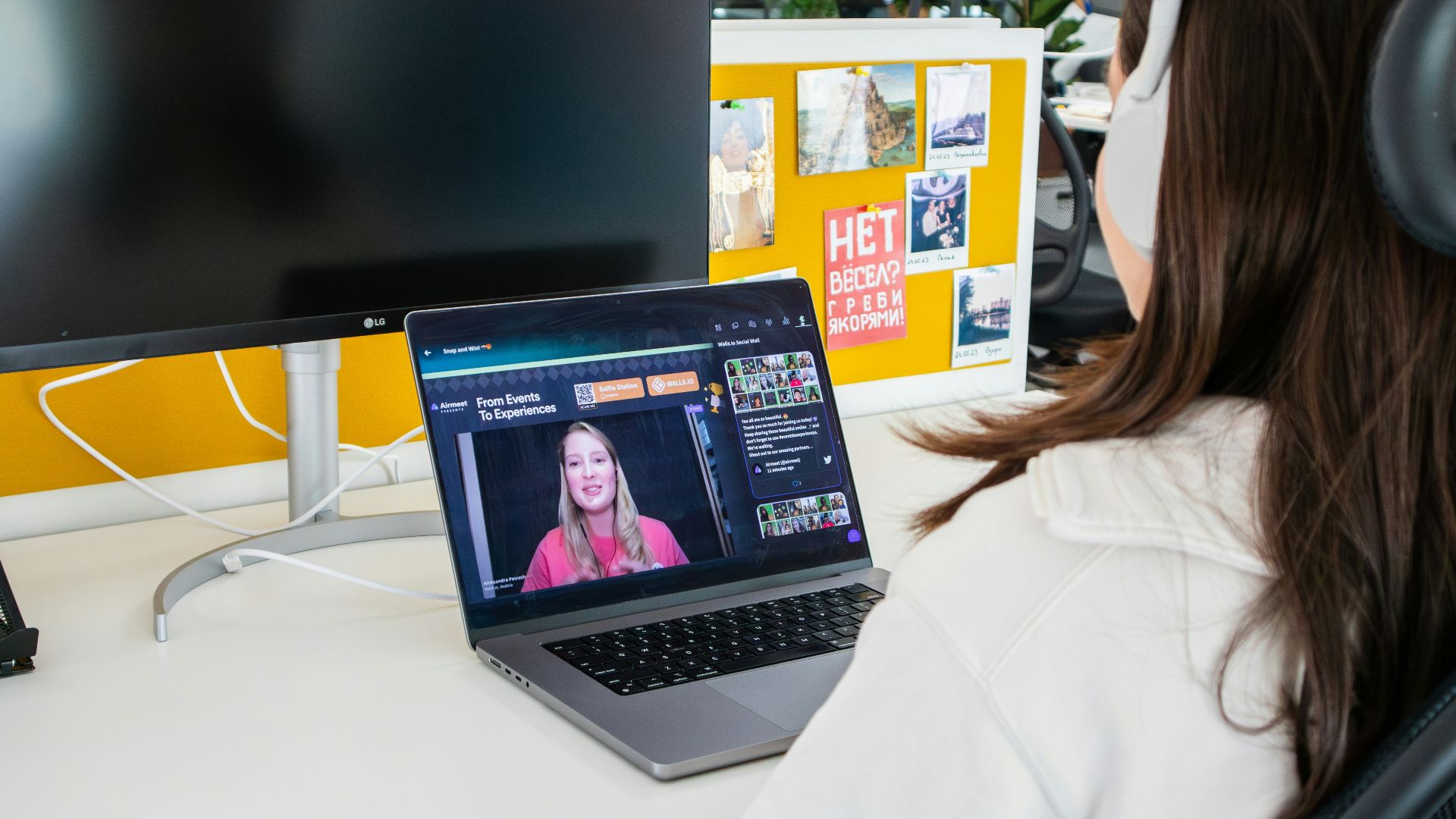 a woman sitting in front of a computer monitor