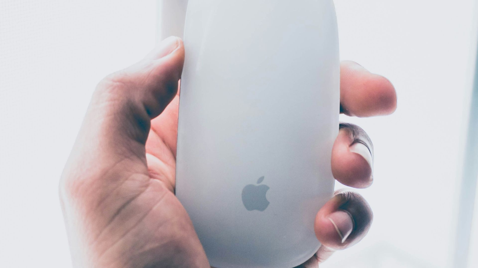person holding Apple Magic mouse