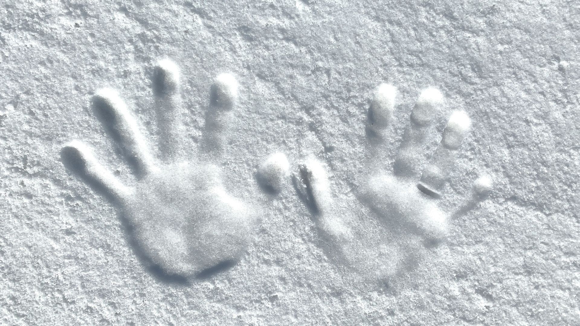 persons hand shadow on gray sand