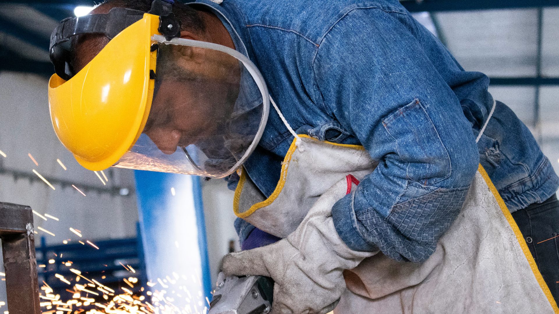 person in blue denim jeans and white and gray gloves holding yellow plastic bucket