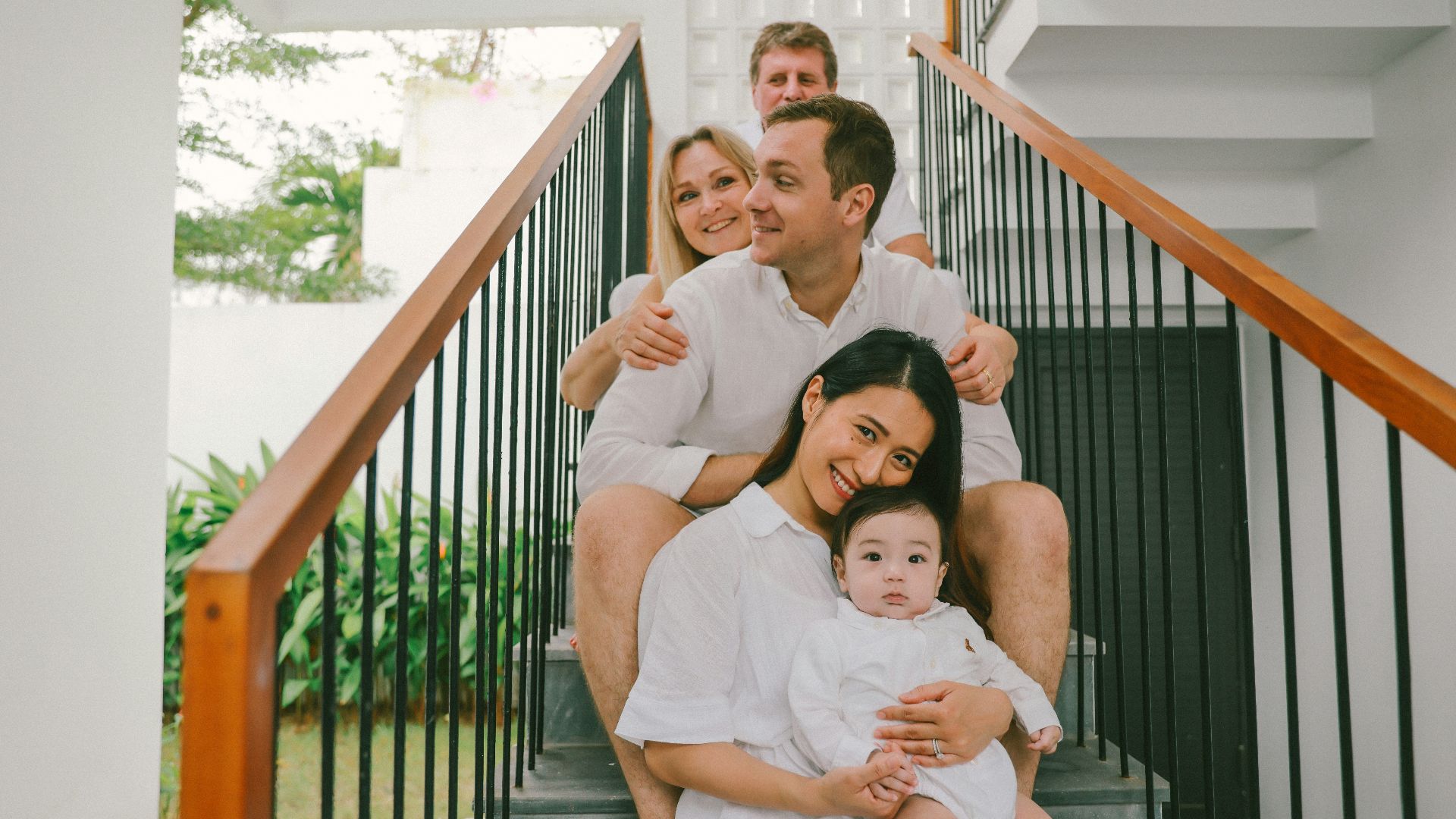Family sitting on stairs, dressed in white