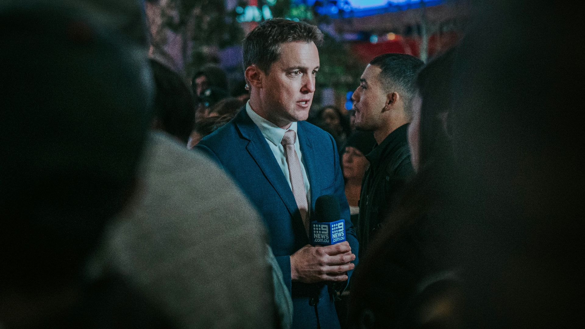 man in black suit standing in front of man in black suit
