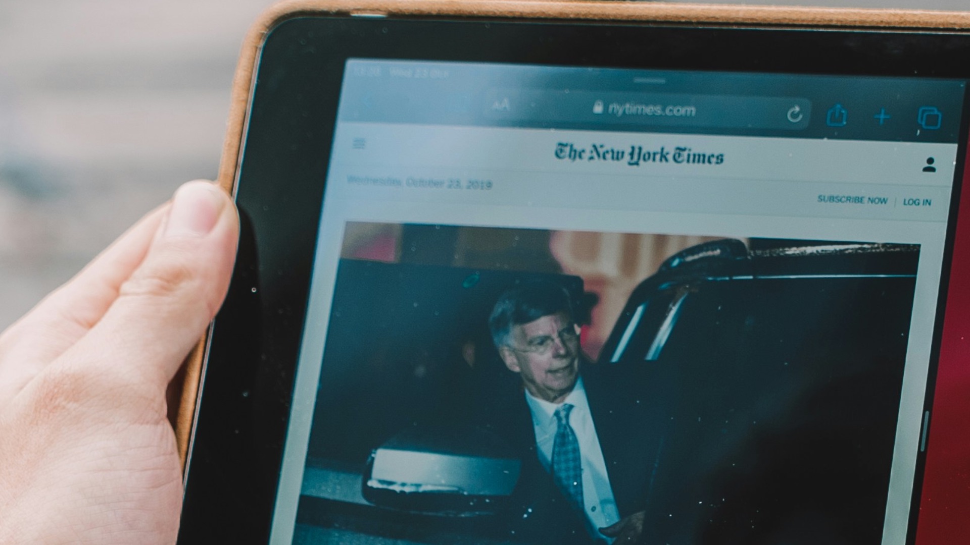 man wearing green long-sleeved shirt using iPad