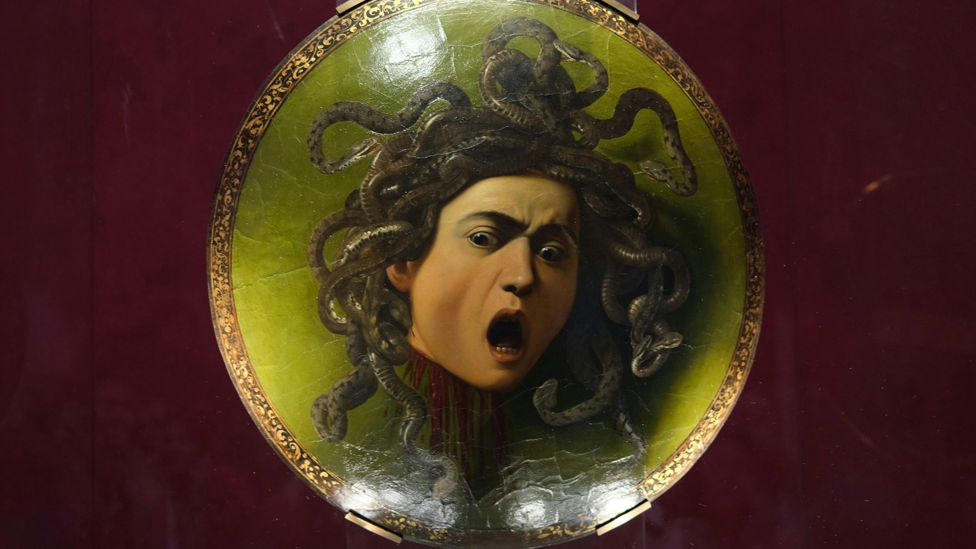 Painting of medusa's head with snakes for hair.