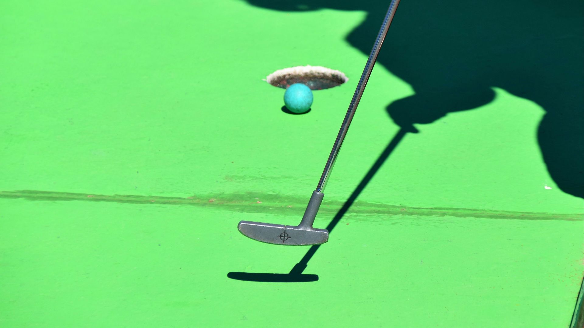 person golfing and ball about to shoot in hole