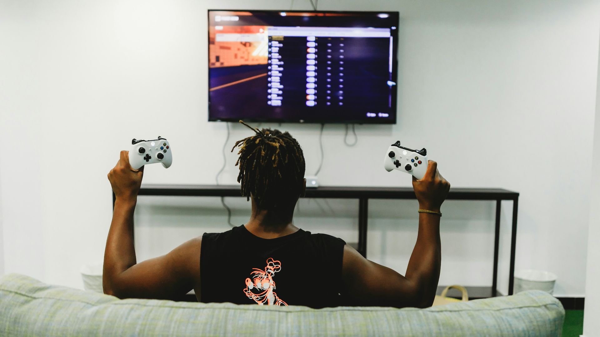 man sitting on couch holding controllers