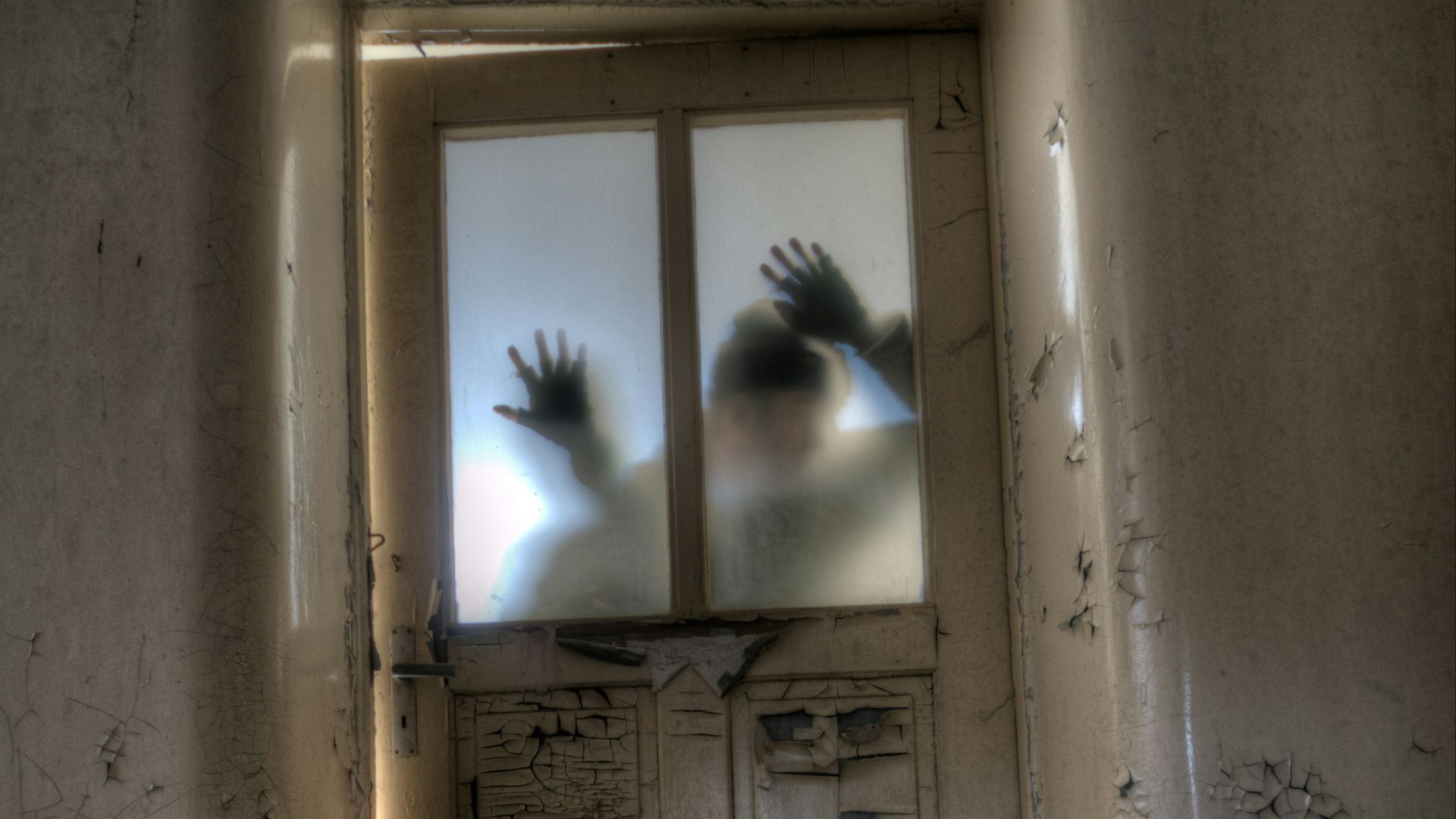 man leaning on frosted glass panel door
