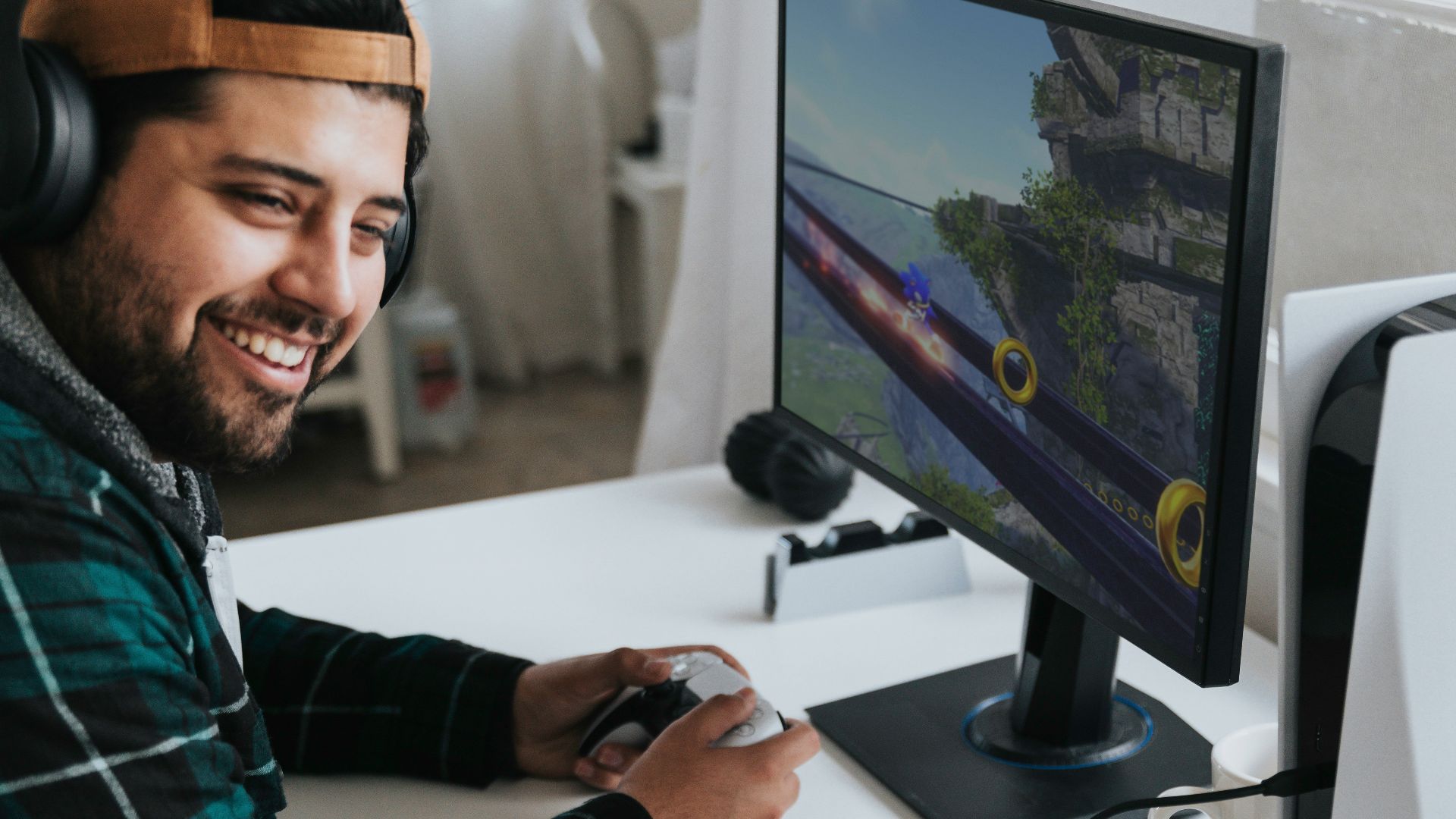 a man wearing headphones and sitting at a desk with a computer