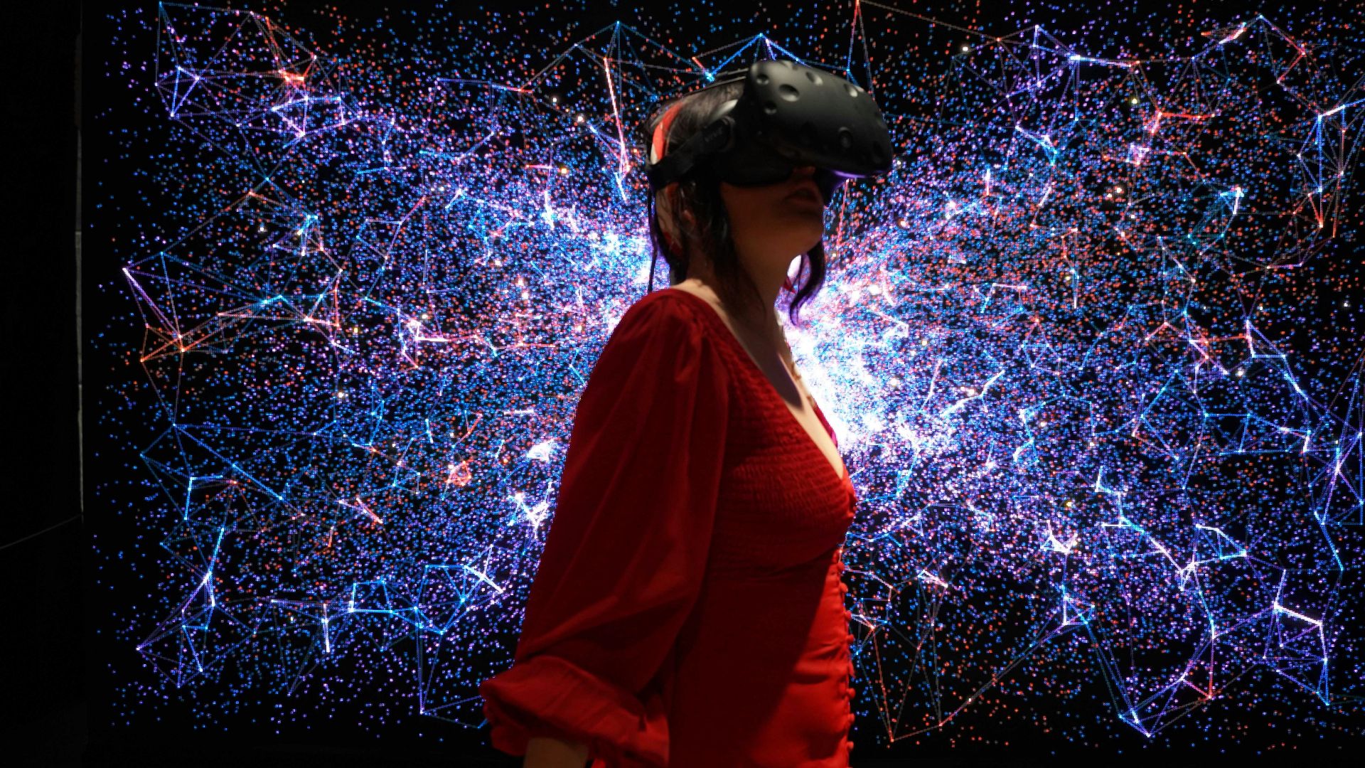 a woman in a red dress wearing a virtual reality headset