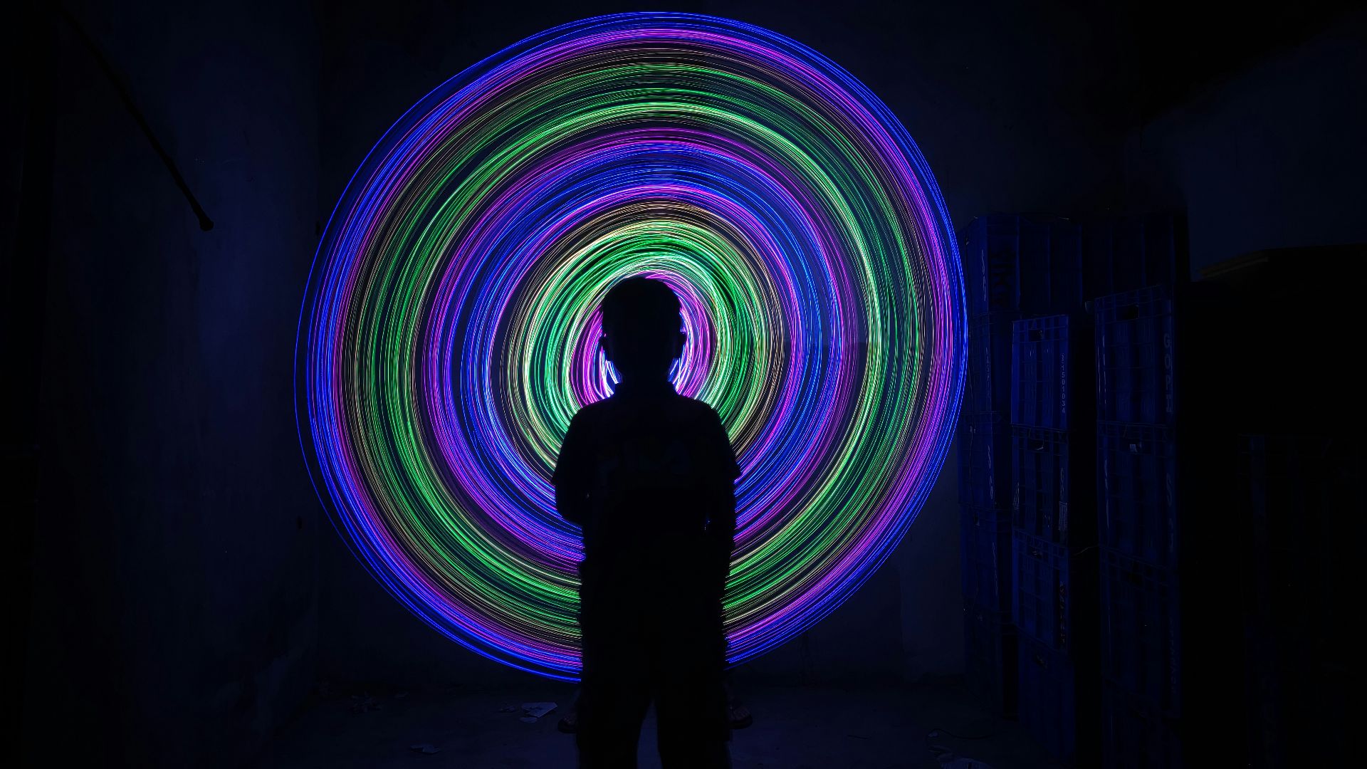 a person standing in a dark room with a bright light in the middle