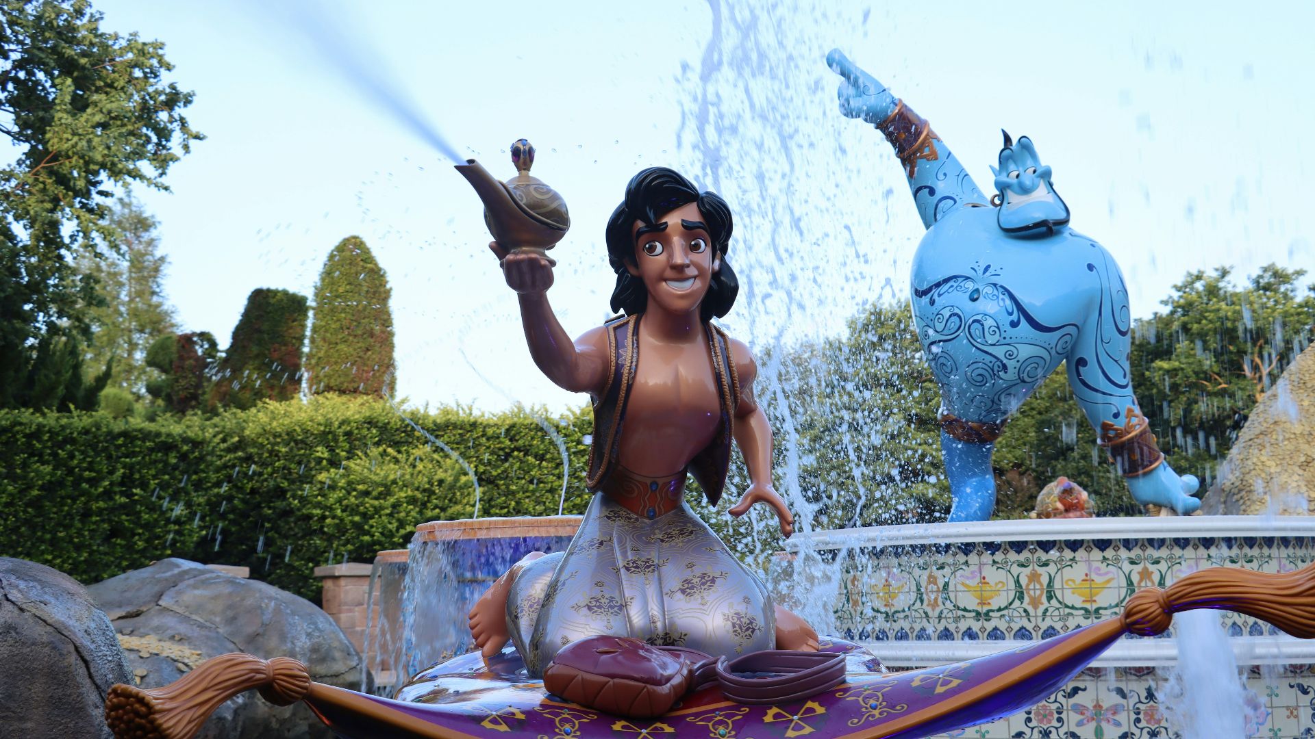 a woman sitting on a fountain with a statue of a man holding a sword