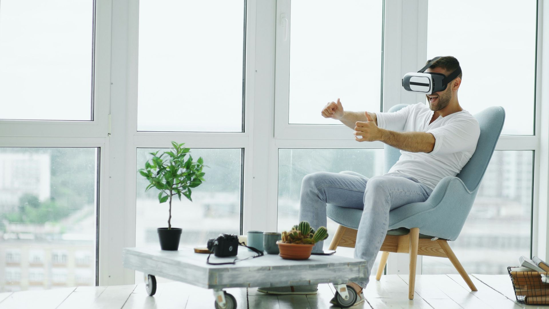 Man wearing vr headset plays game in armchair.