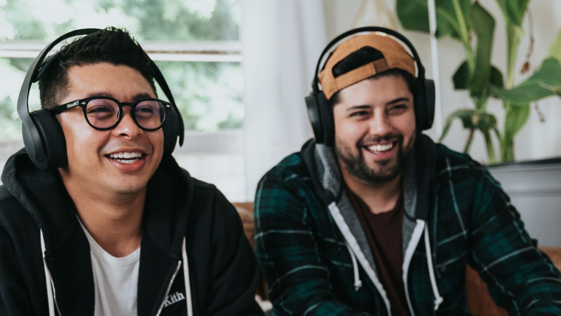 a couple of men sitting at a table with game controllers
