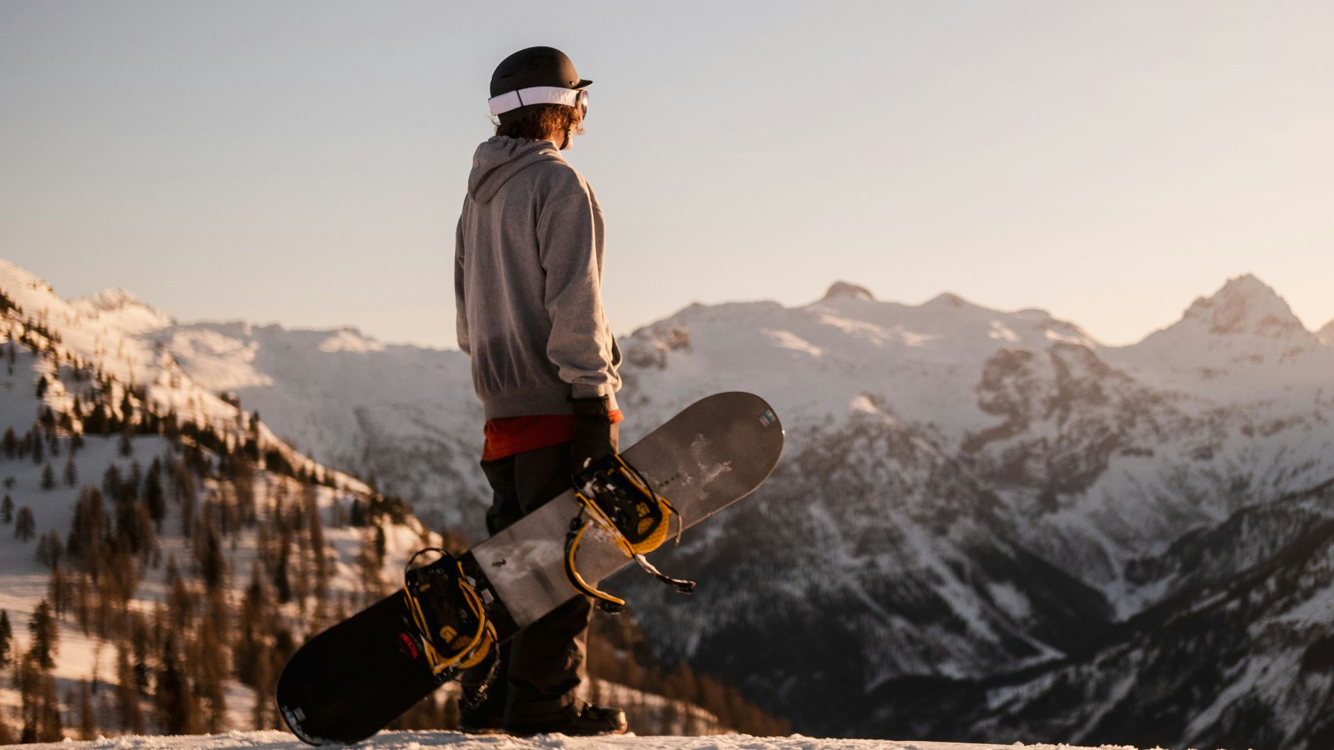 man in white jacket and black pants standing on brown rock formation during daytime