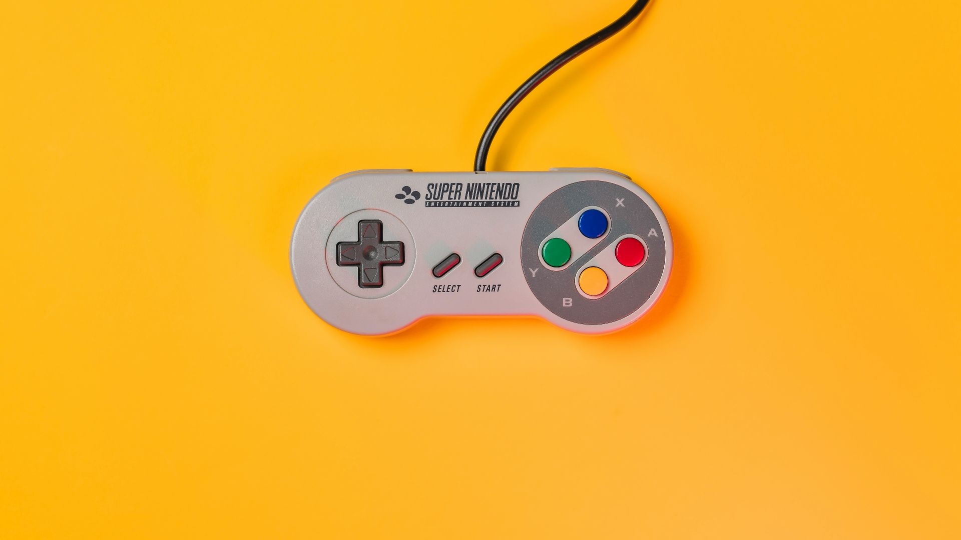 white nintendo game controller on yellow surface