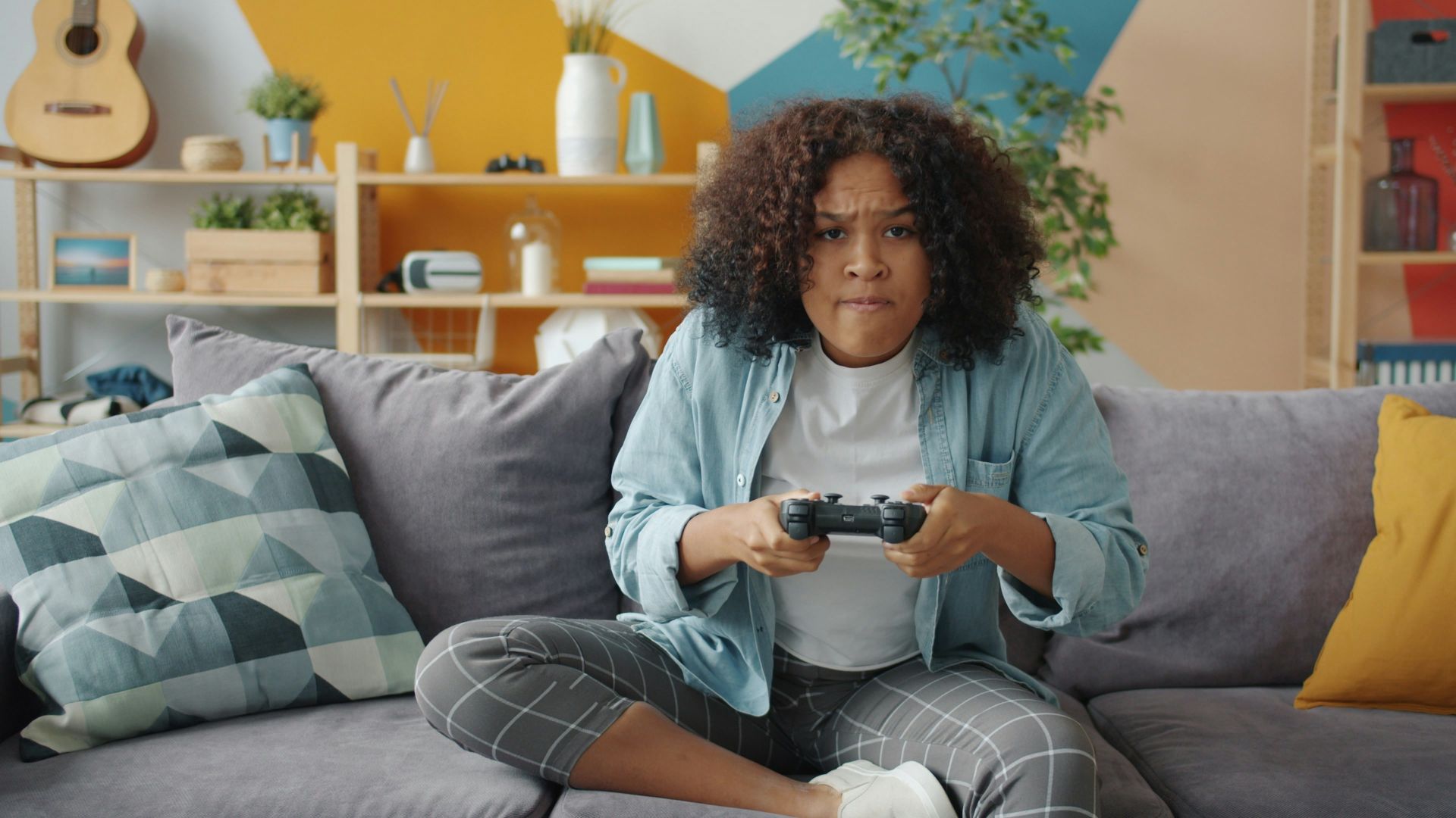 Young woman intensely playing video games on couch