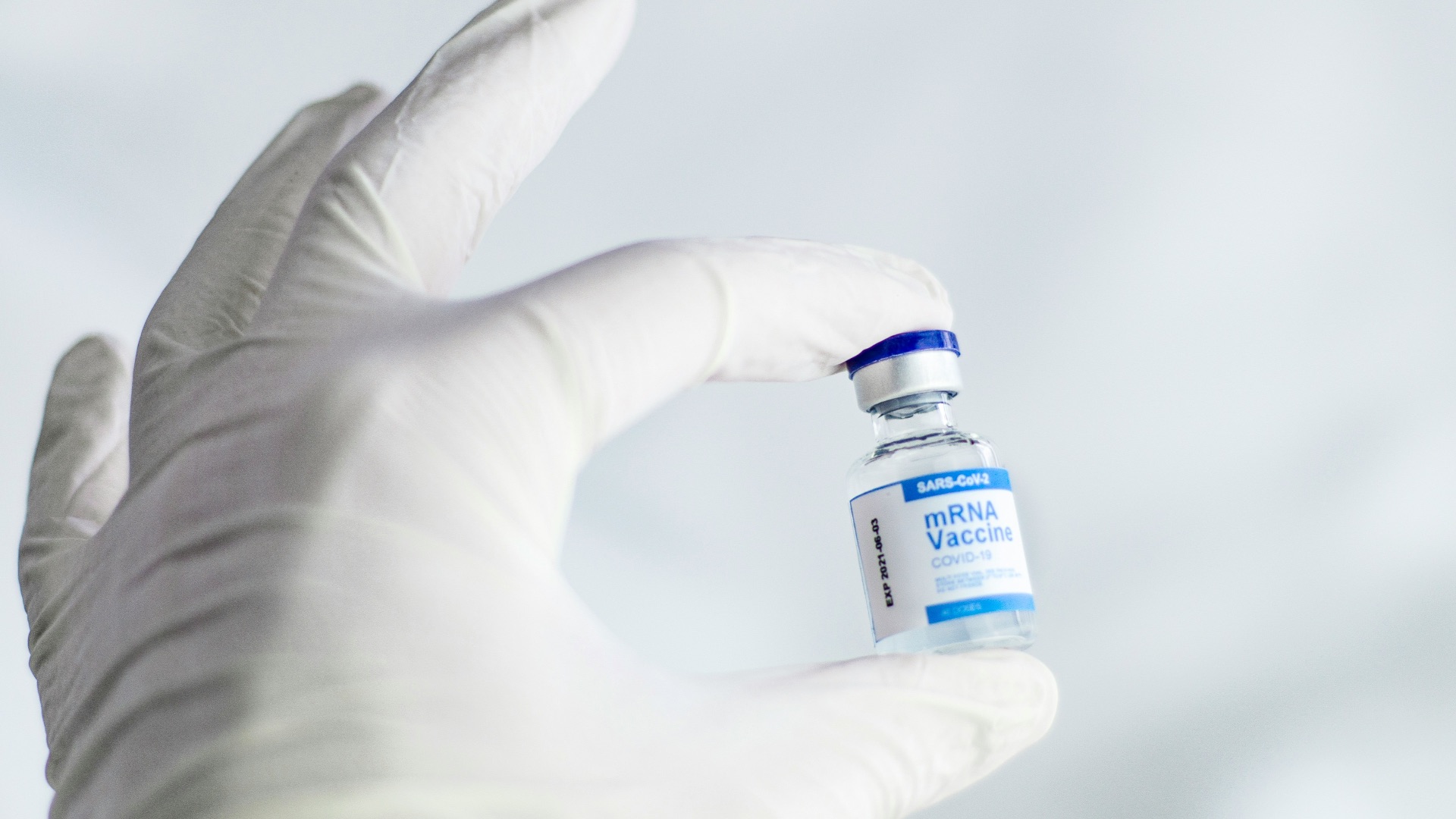 person holding white and orange plastic bottle