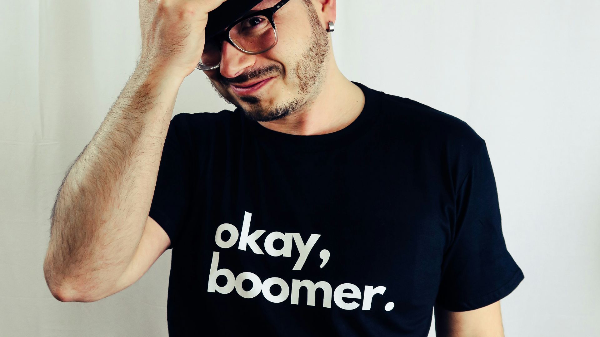 man in black crew neck t-shirt wearing black fedora hat