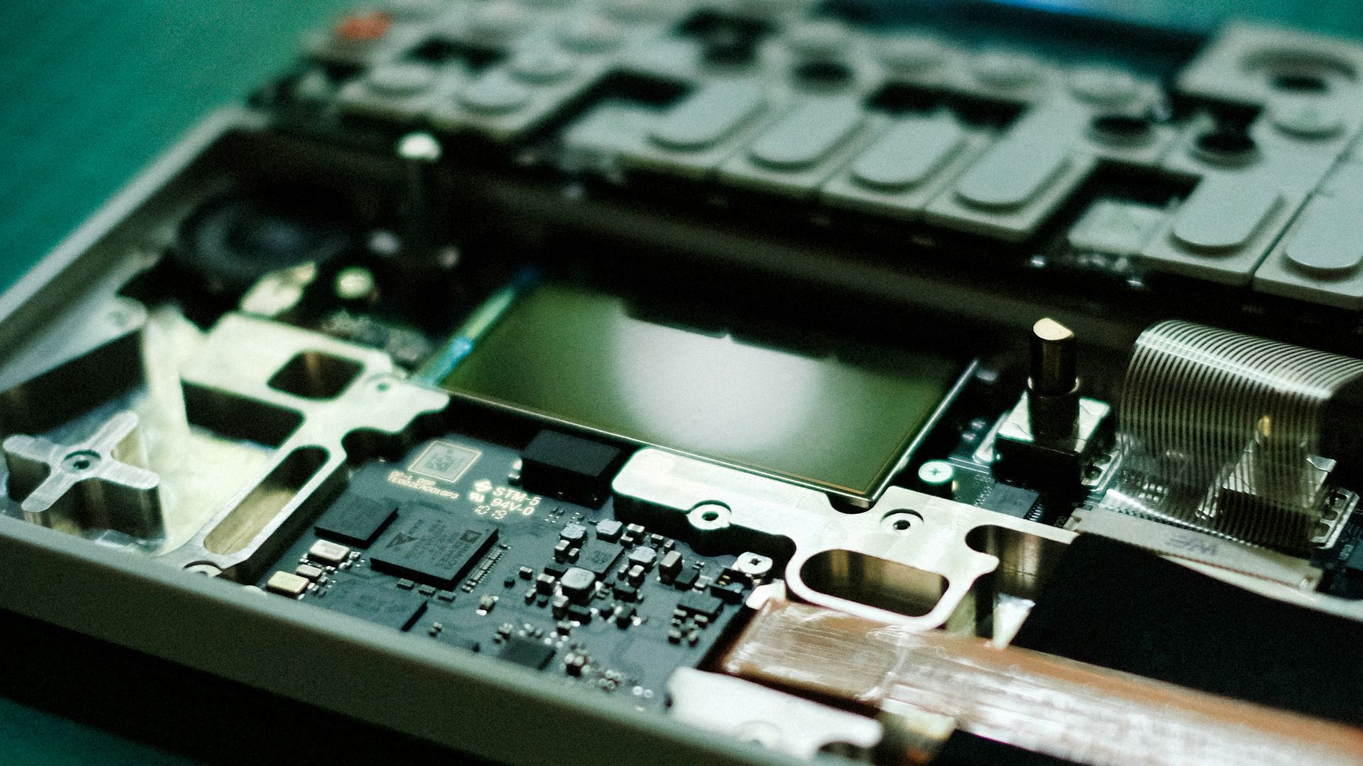 A laptop's disassembled internals on a workbench.