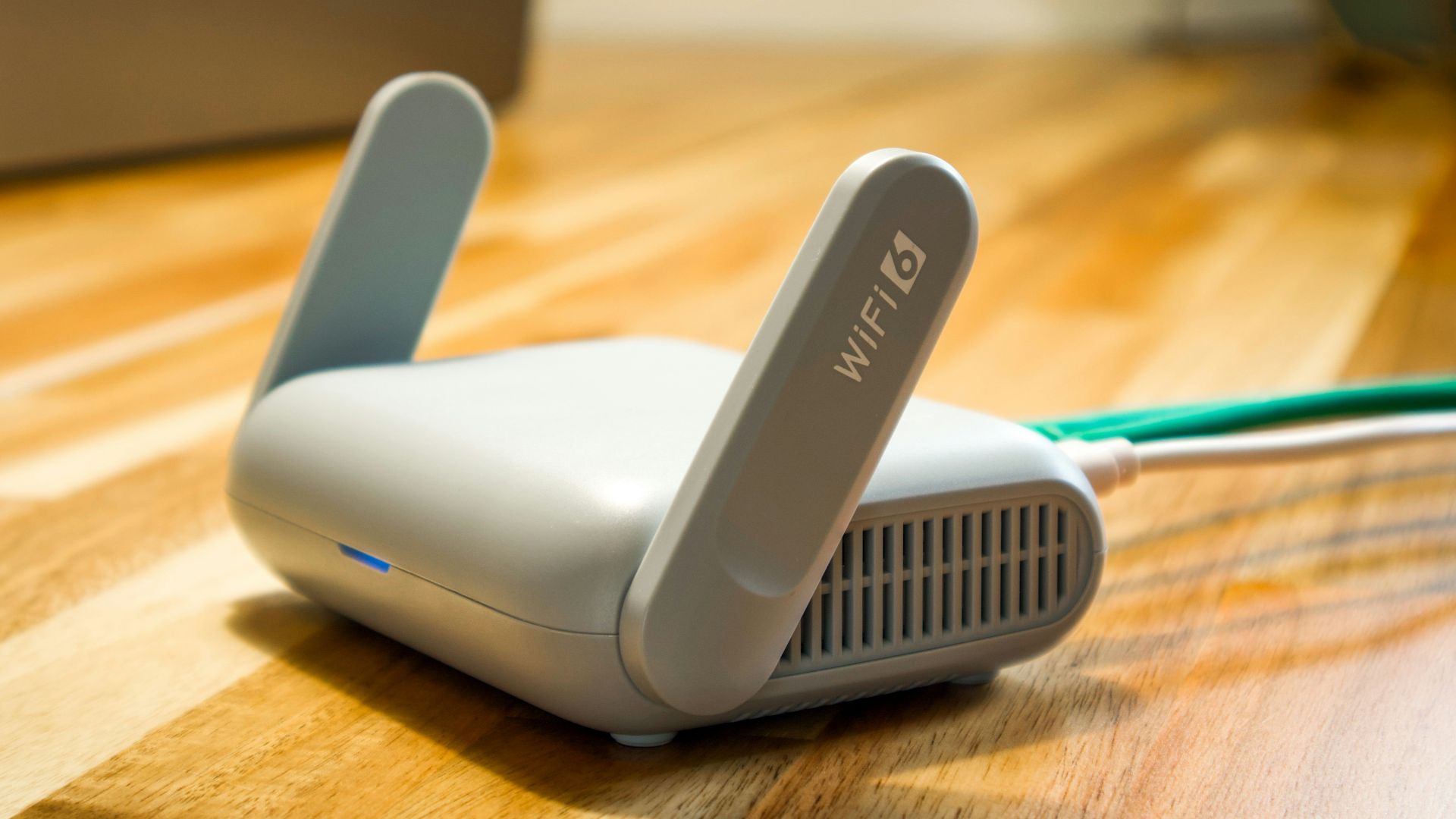 A wireless router sits on a wooden table.