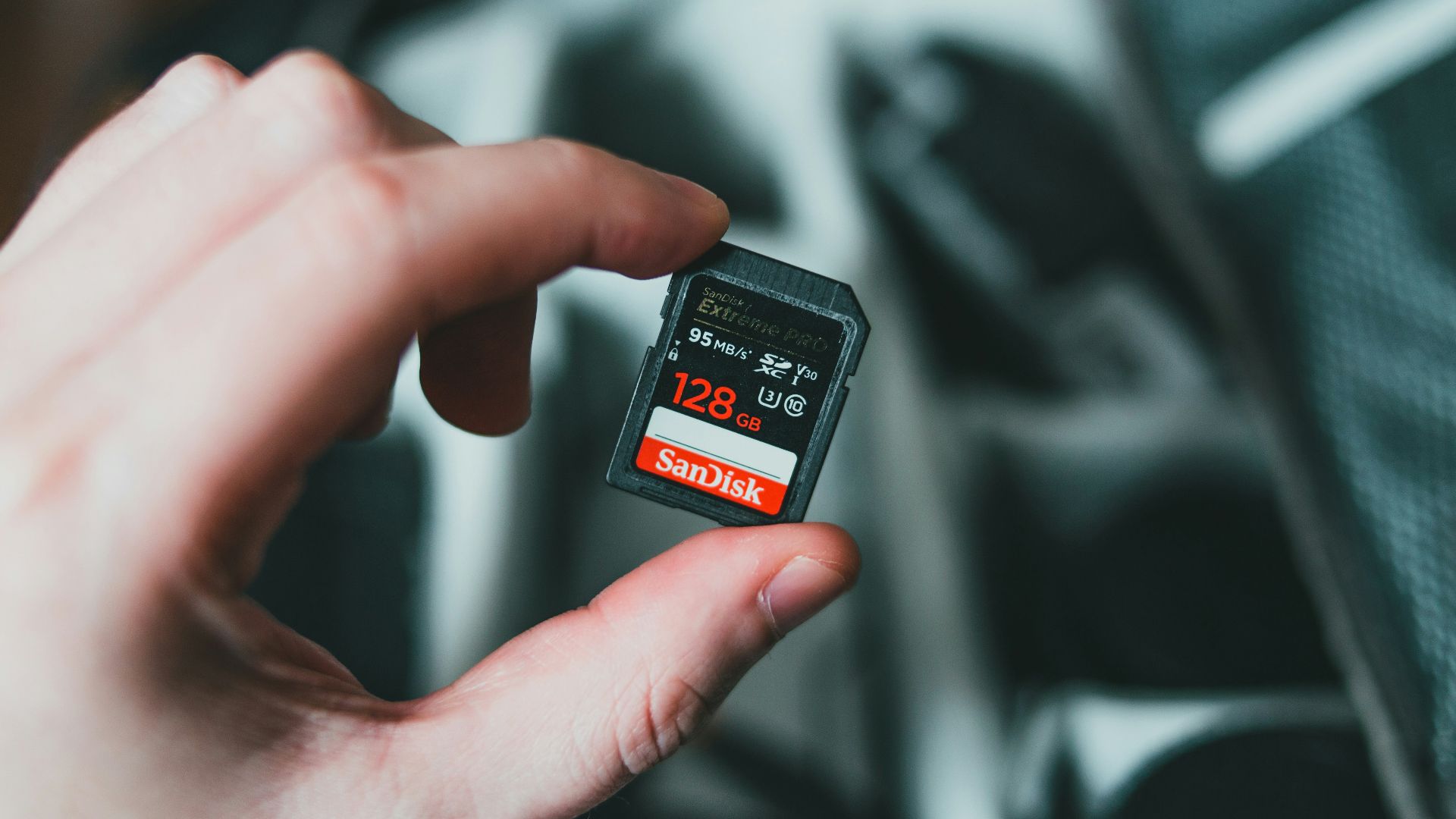 person holding black and red nintendo game cartridge