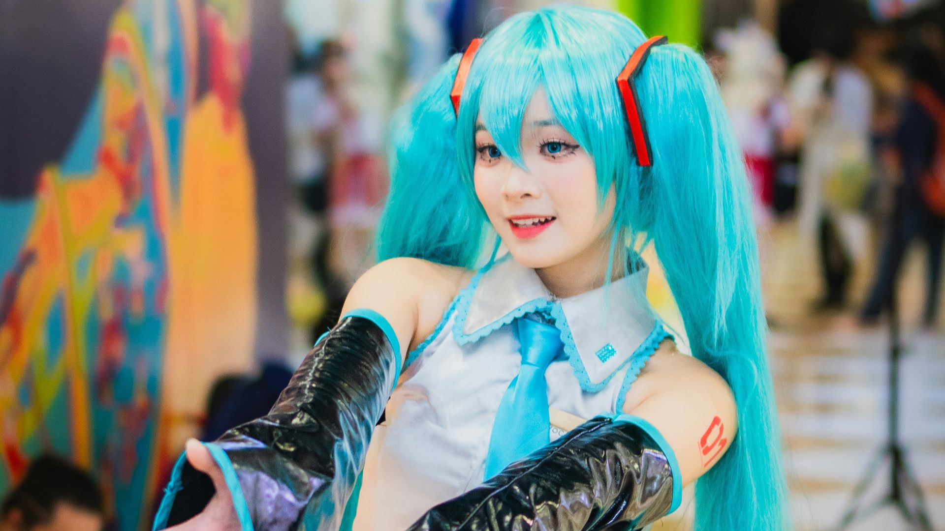 A woman with long blue hair is posing for a picture