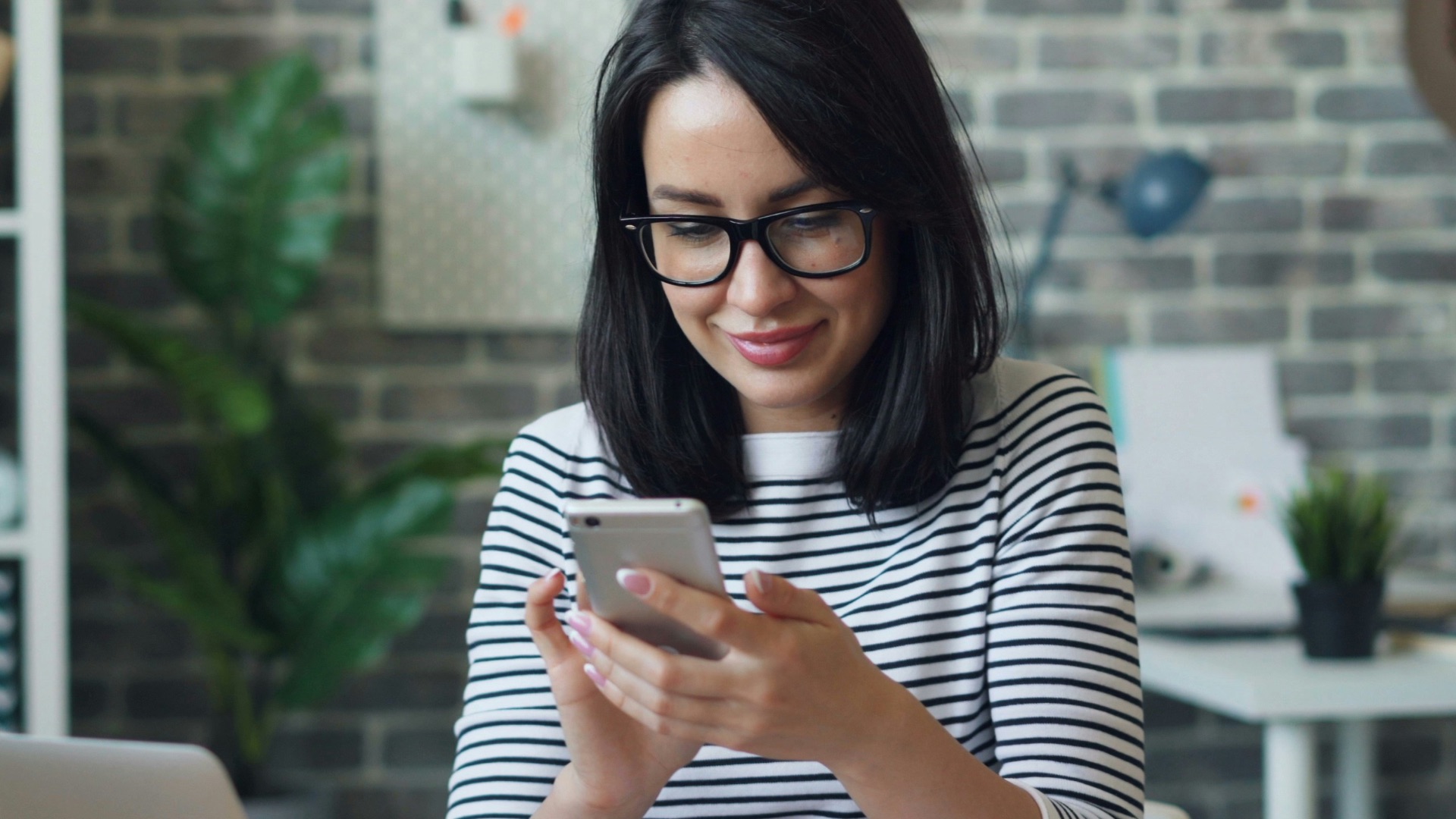 a woman sitting at a table looking at her cell phone