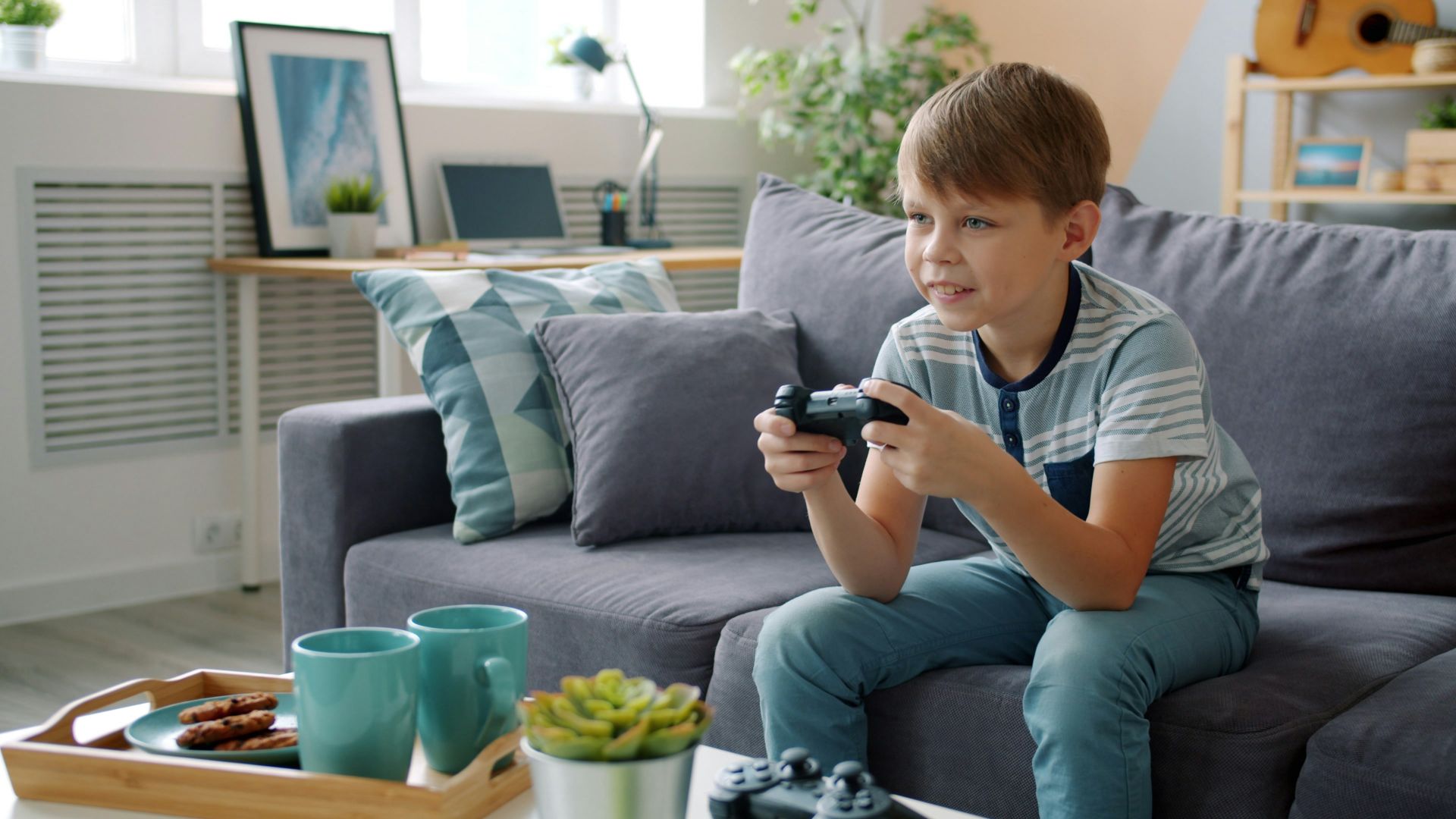 Young boy playing video games on couch