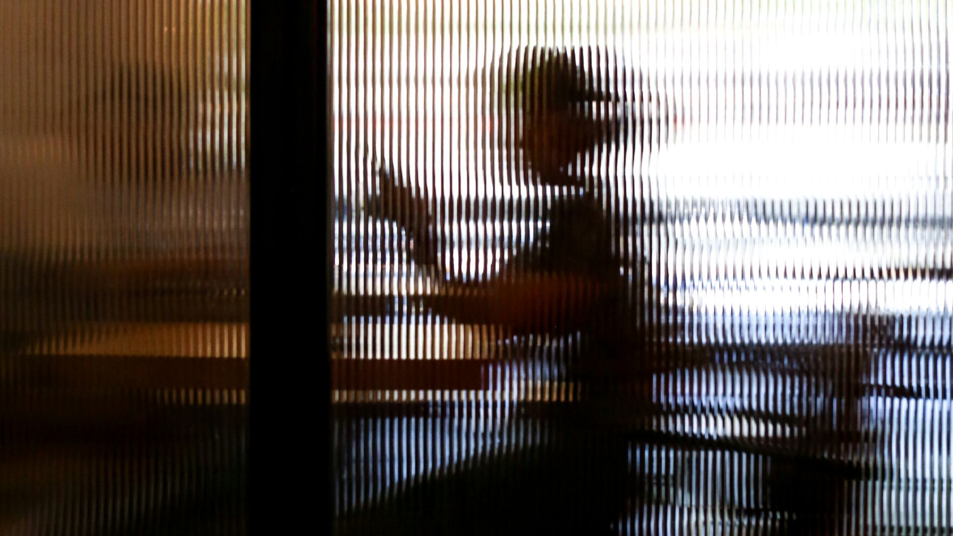 2 people sitting on chair near window during sunset