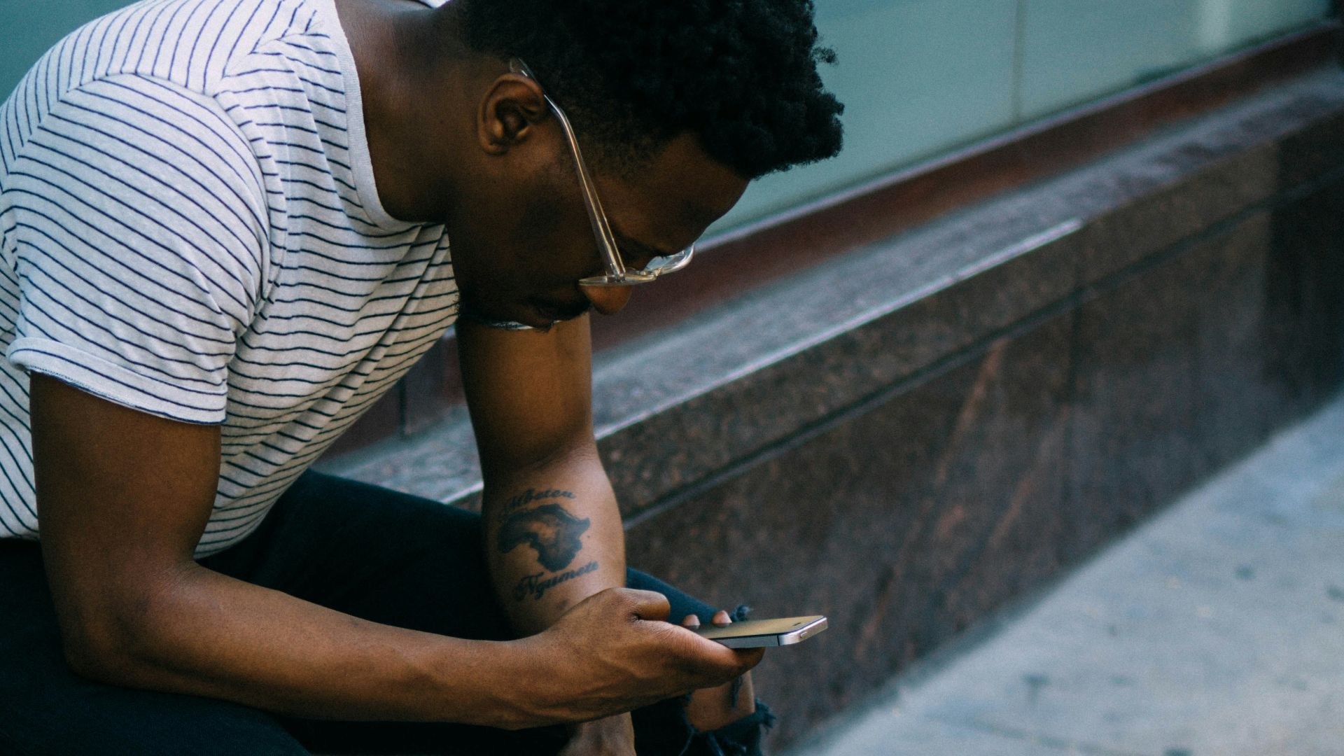 man sitting while using phone