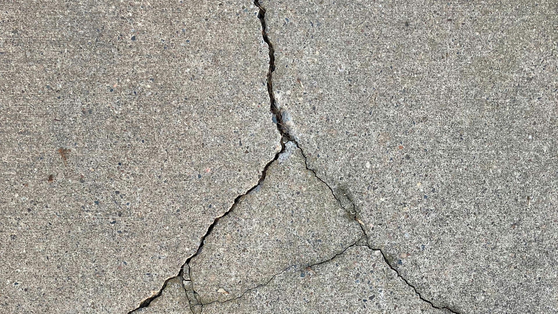 the crack in the concrete shows a crack in the road