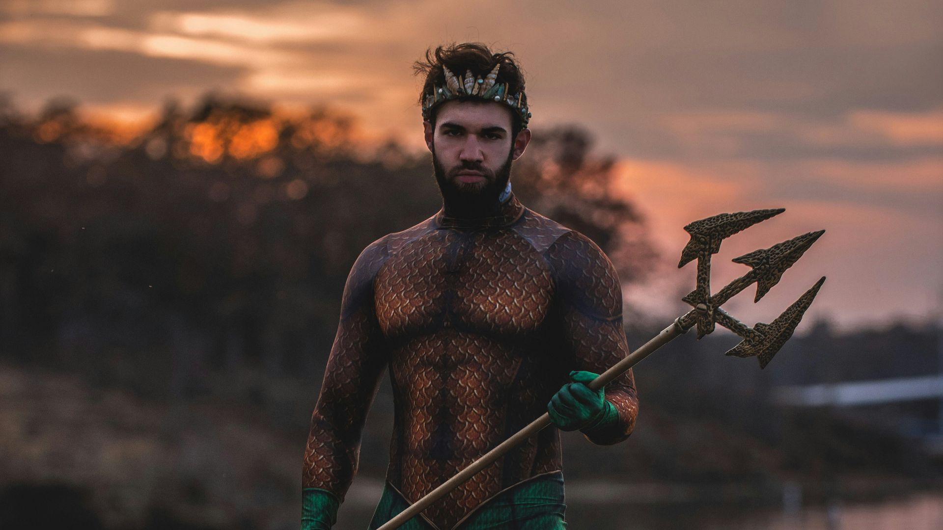 man wearing Poseidon costume standing on rock