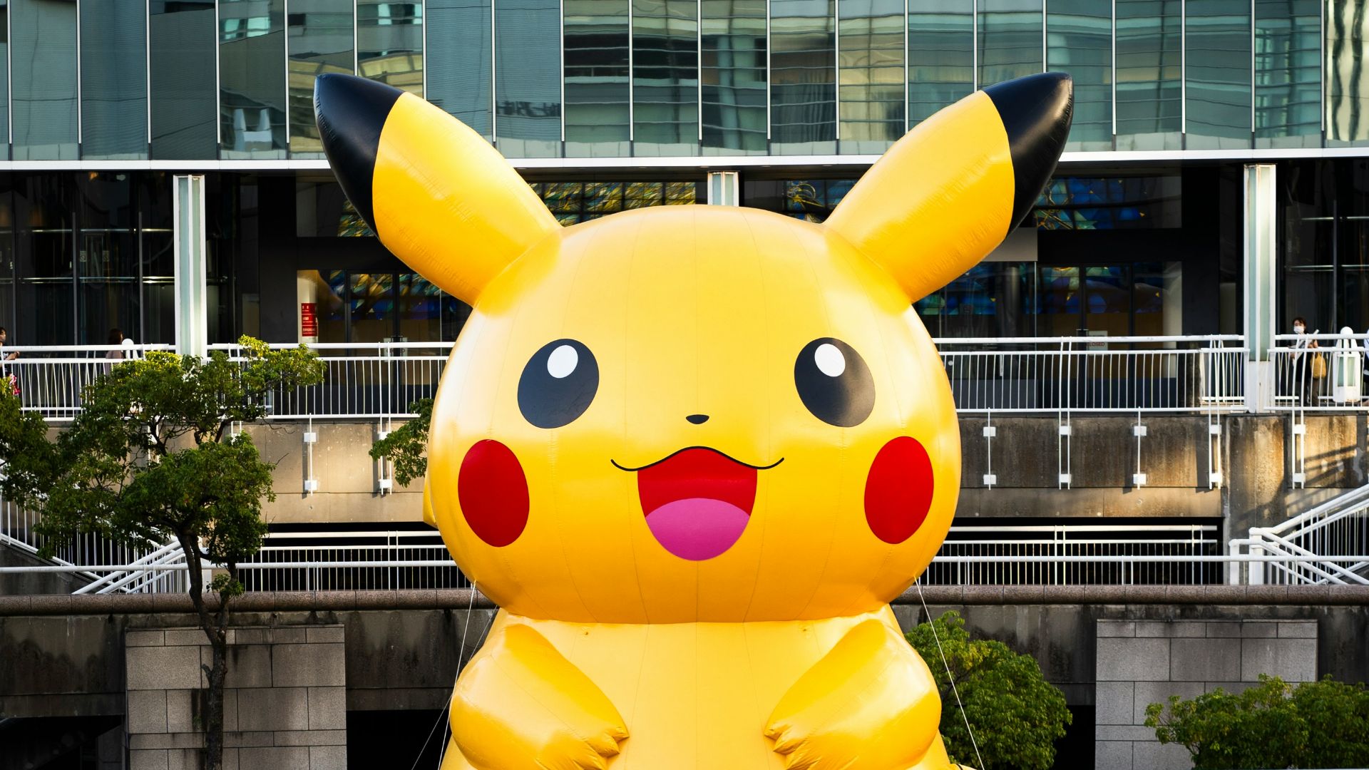 A group of people standing in front of a giant pikachu