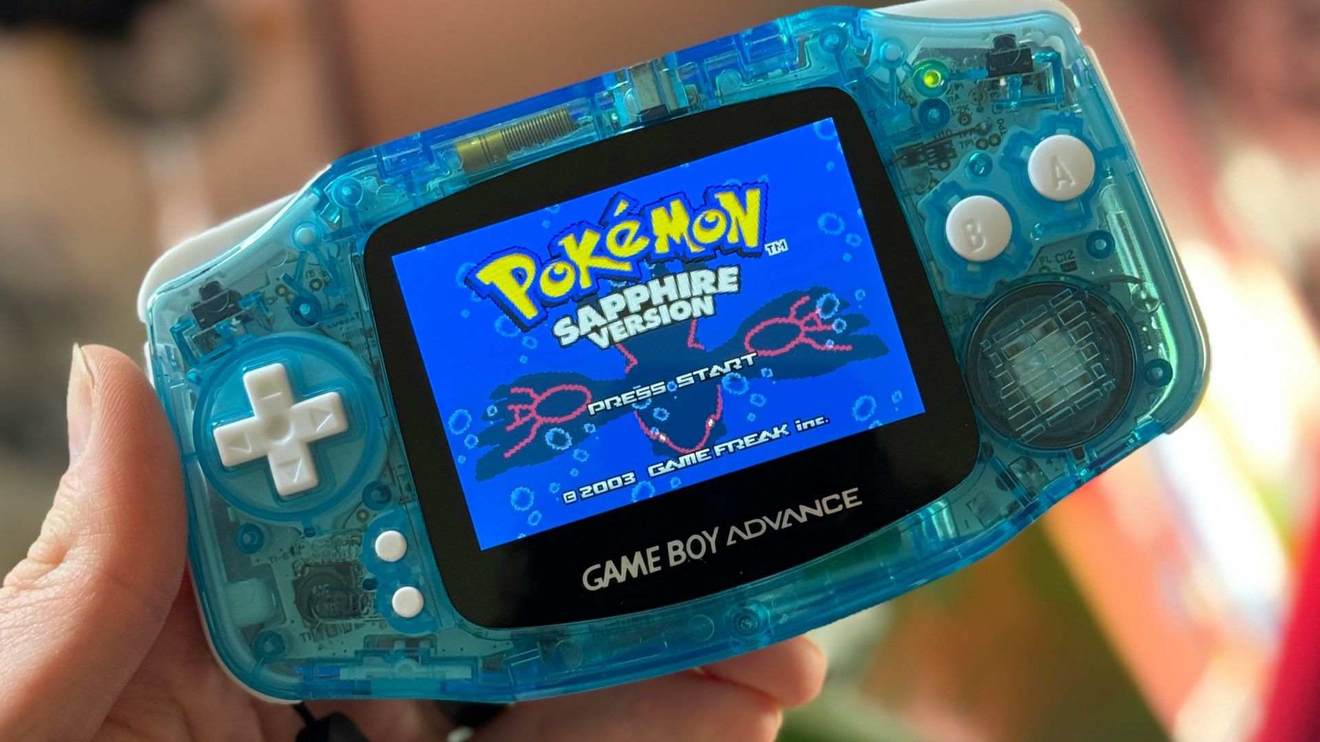 a person holding a gameboy in their hand