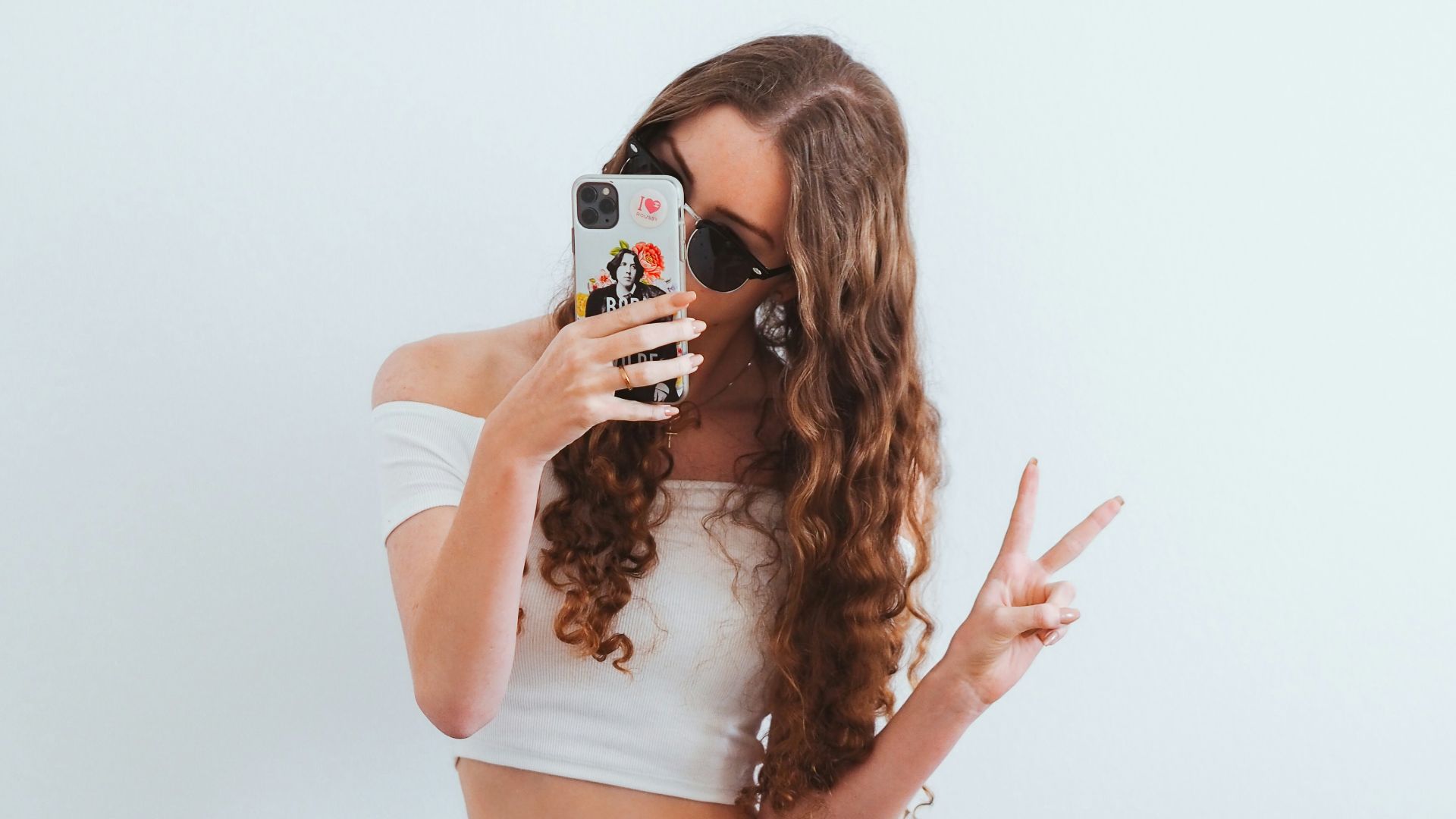 woman in pink tank top and blue denim jeans sitting on yellow chair