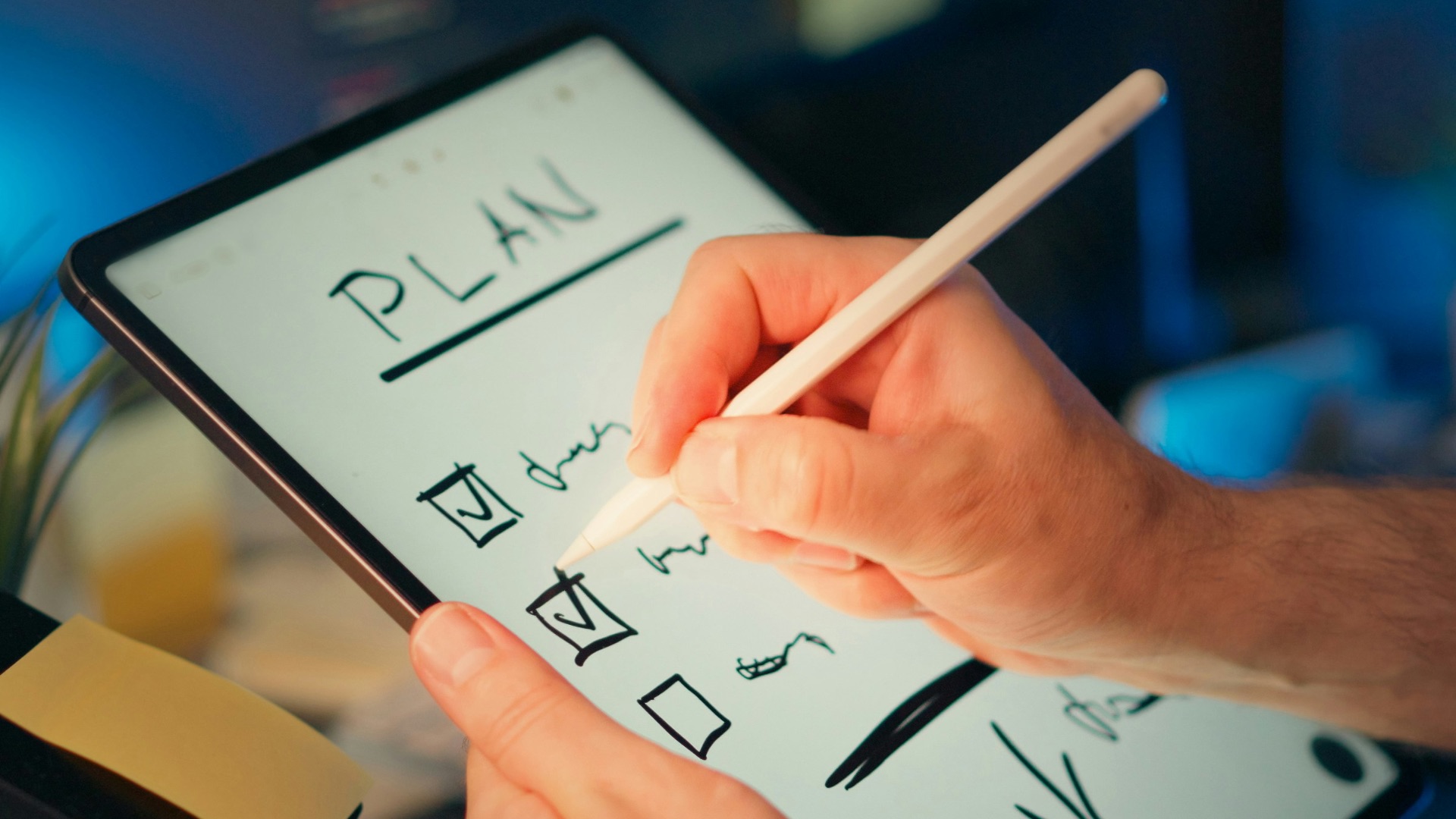 Someone is writing a plan on a tablet.