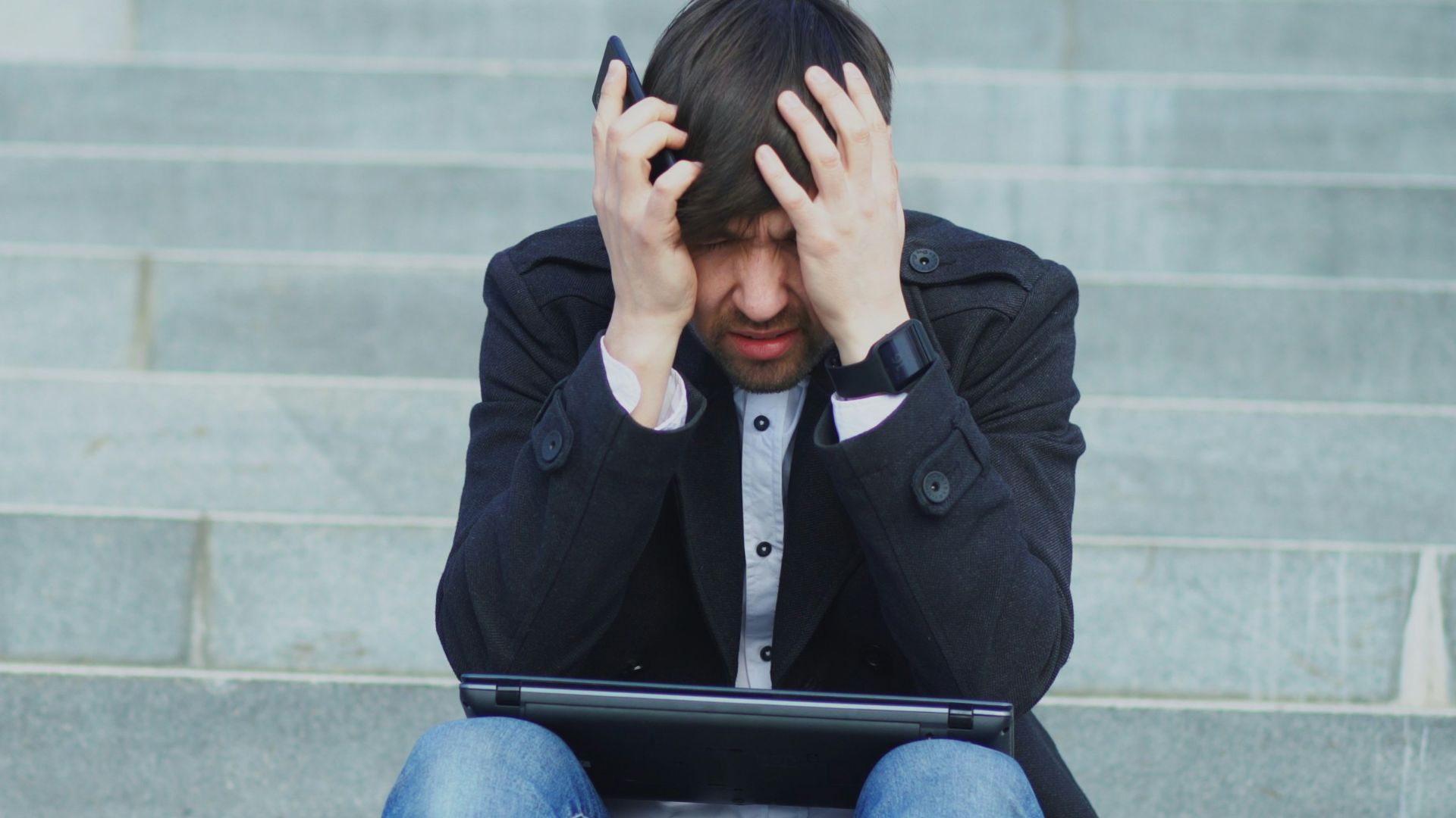 Man sitting on steps with head in hands