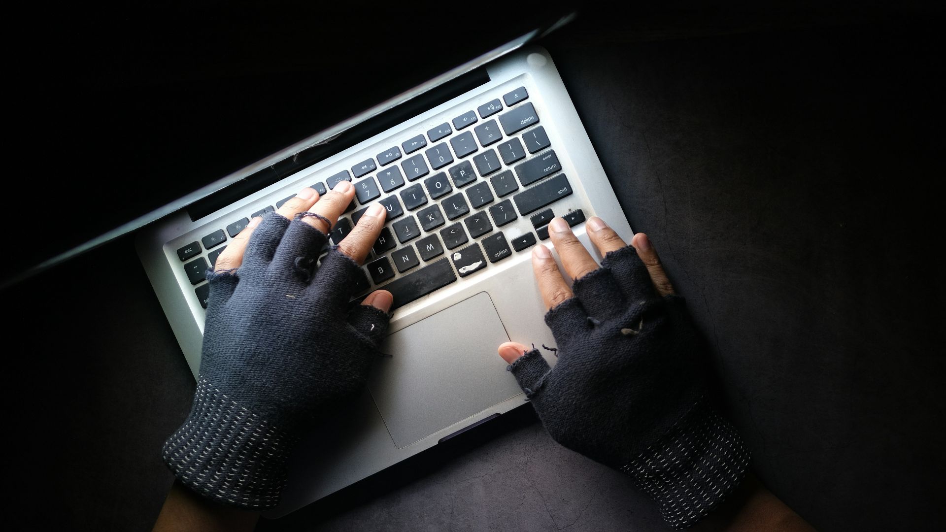 person in black long sleeve shirt using macbook pro