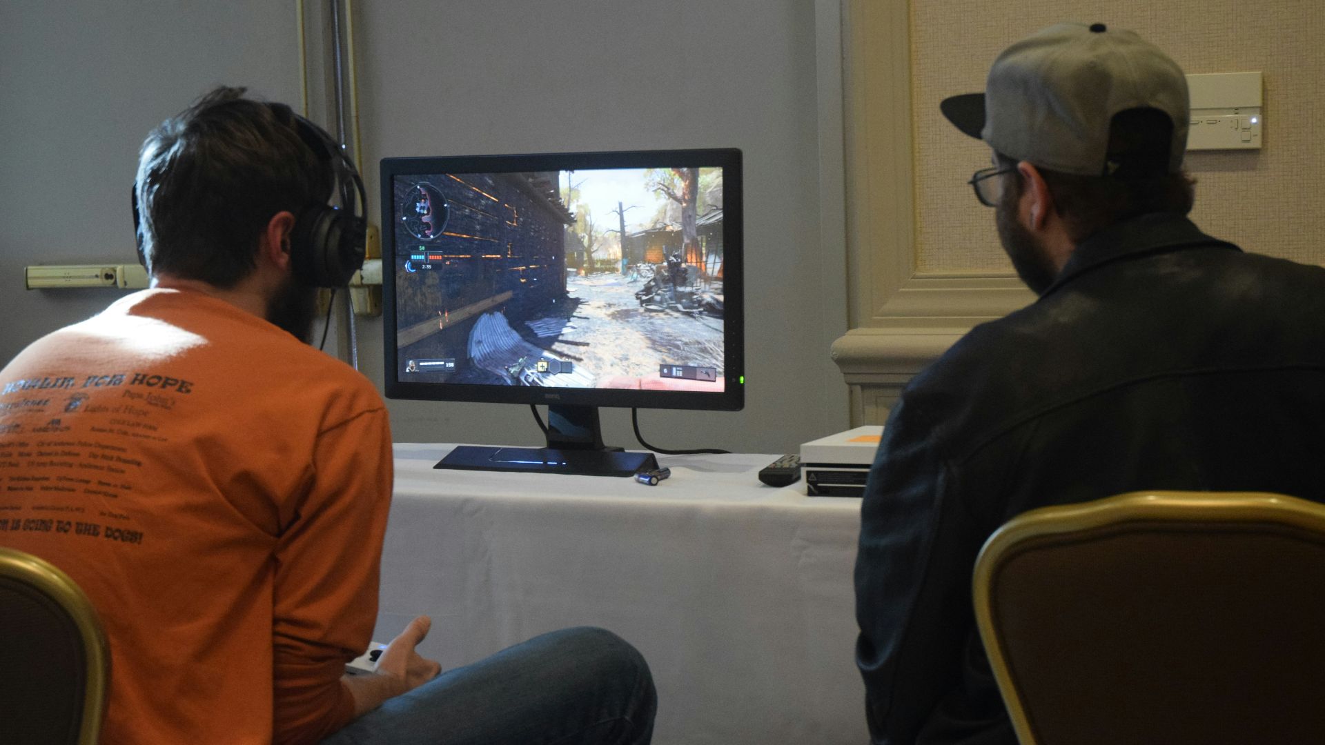 two men playing games facing monitor