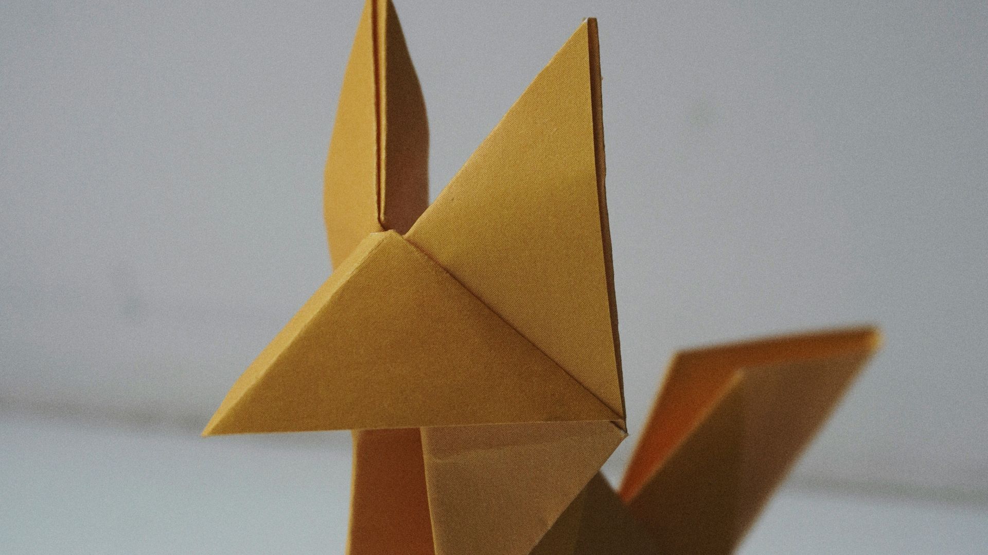 an origami animal made out of gold paper