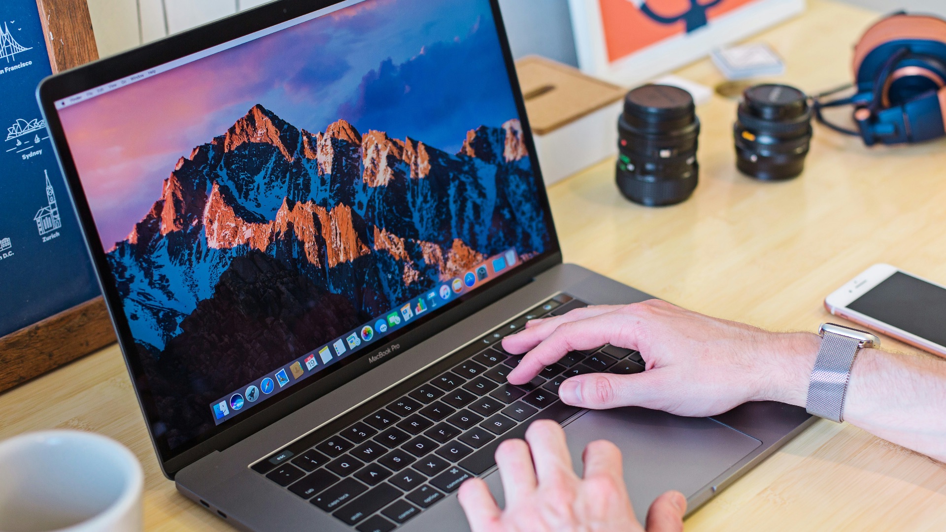MacBook Pro turned on beside white ceramic mug