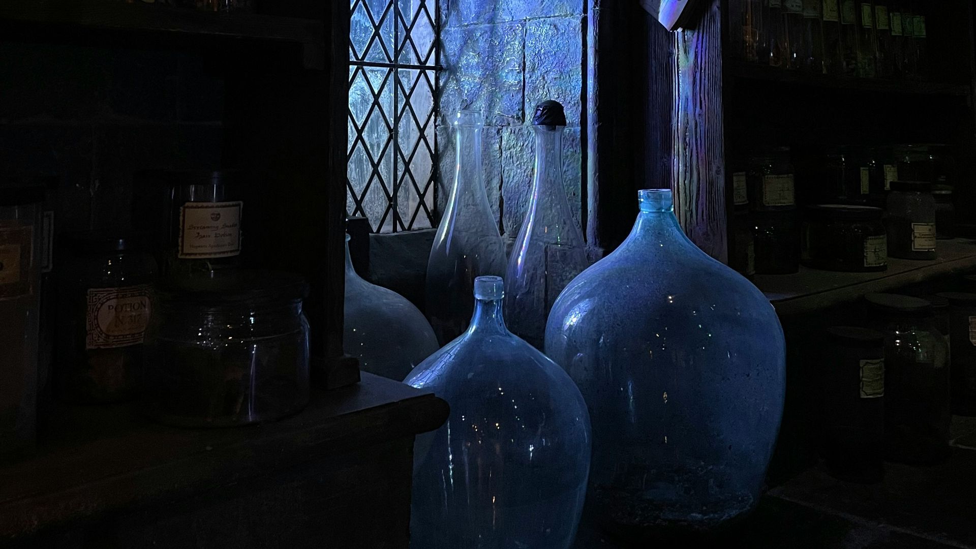 blue glass bottle on brown wooden shelf