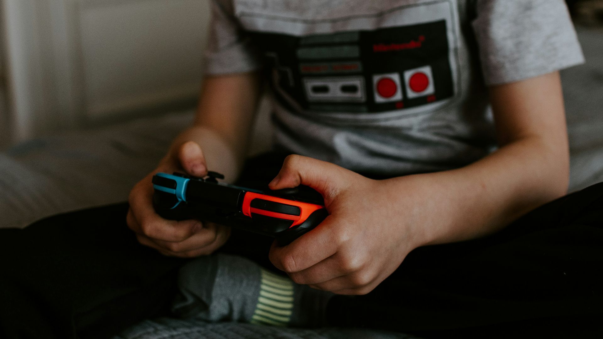 kid sitting on gray bed while playing
