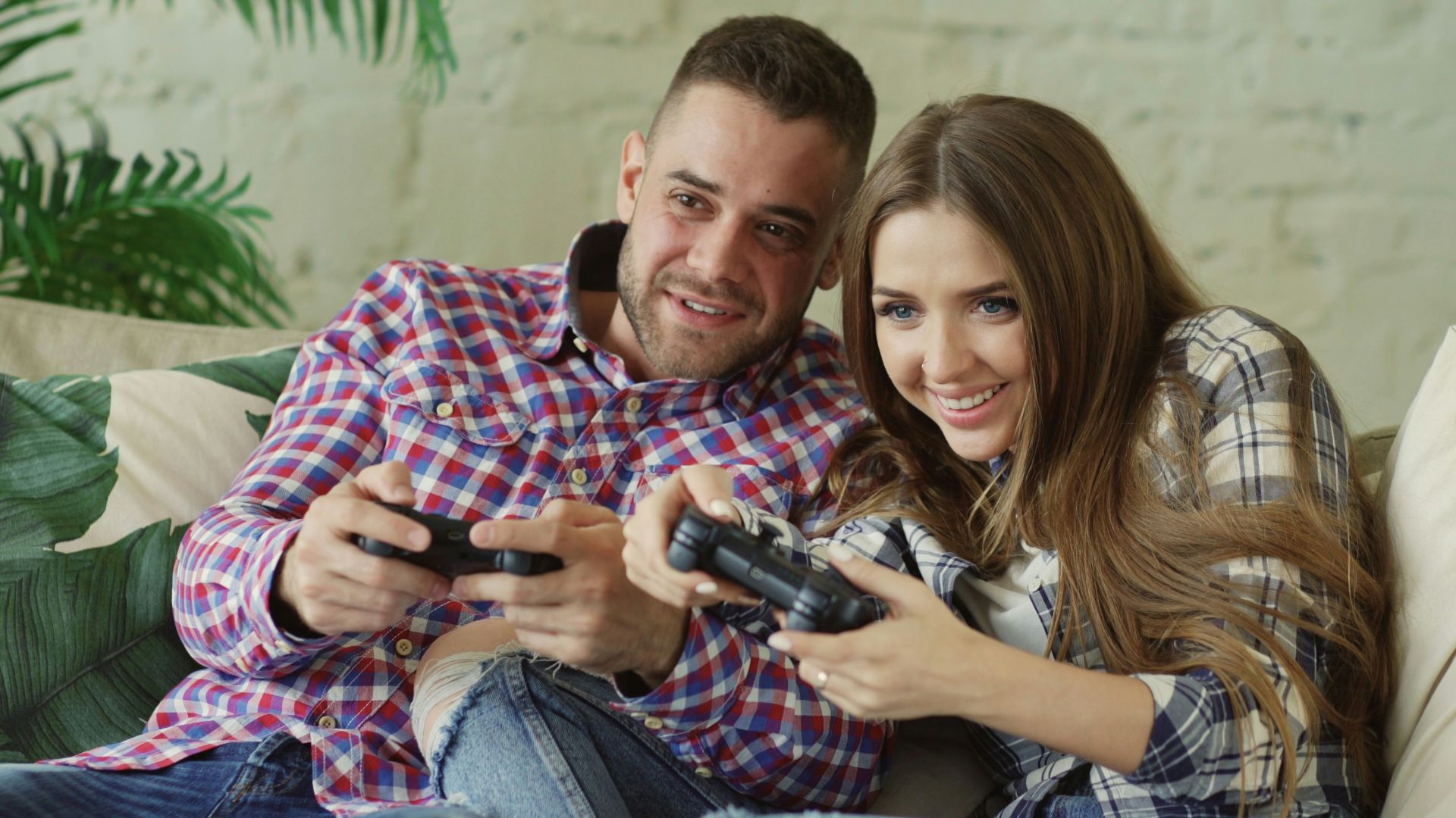 Couple playing video games on couch