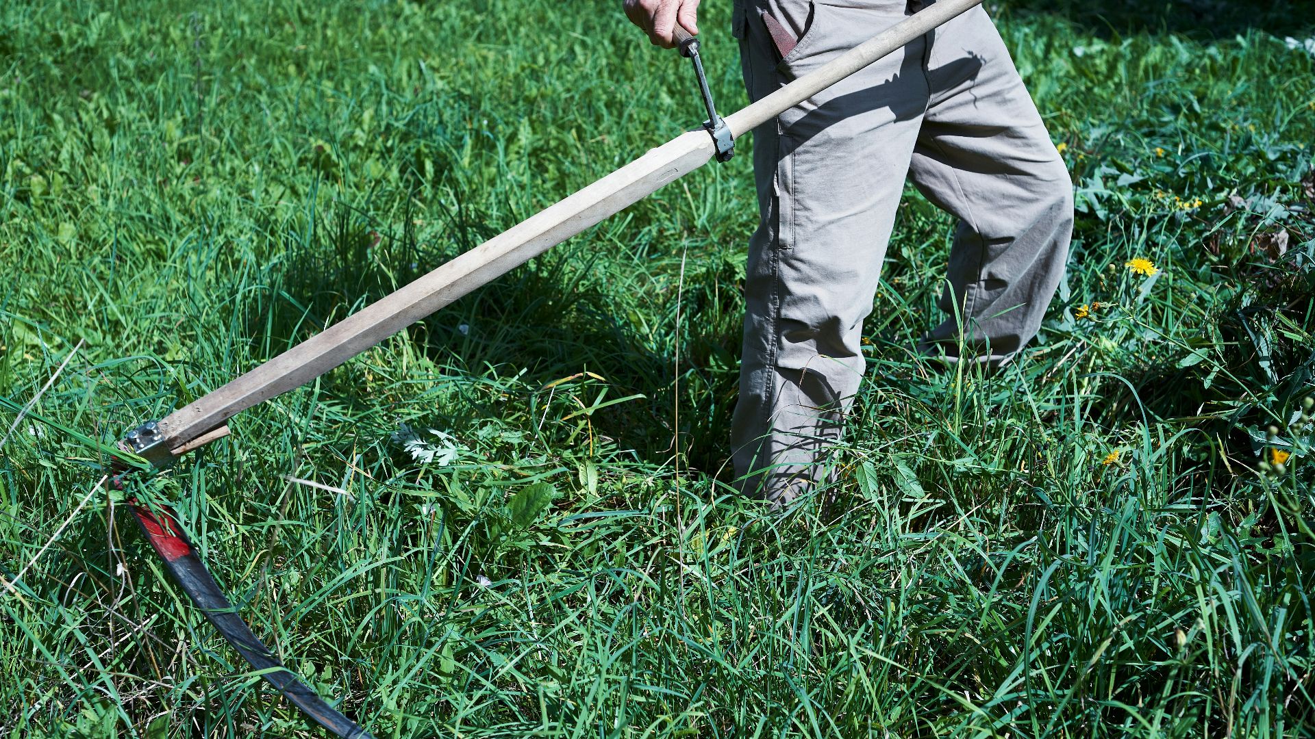 man in black and gray stripe long sleeve shirt and gray pants holding gray metal bar
