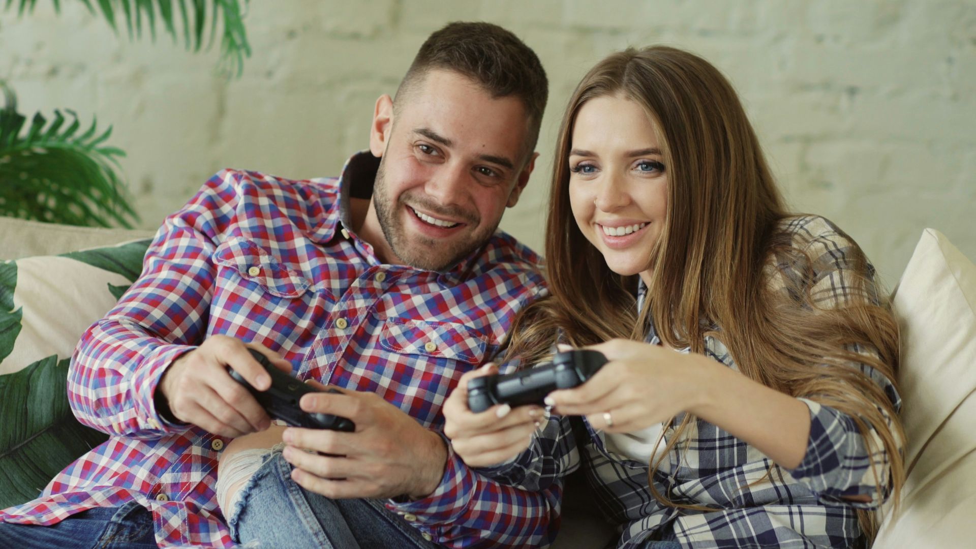 Couple playing video games together on couch