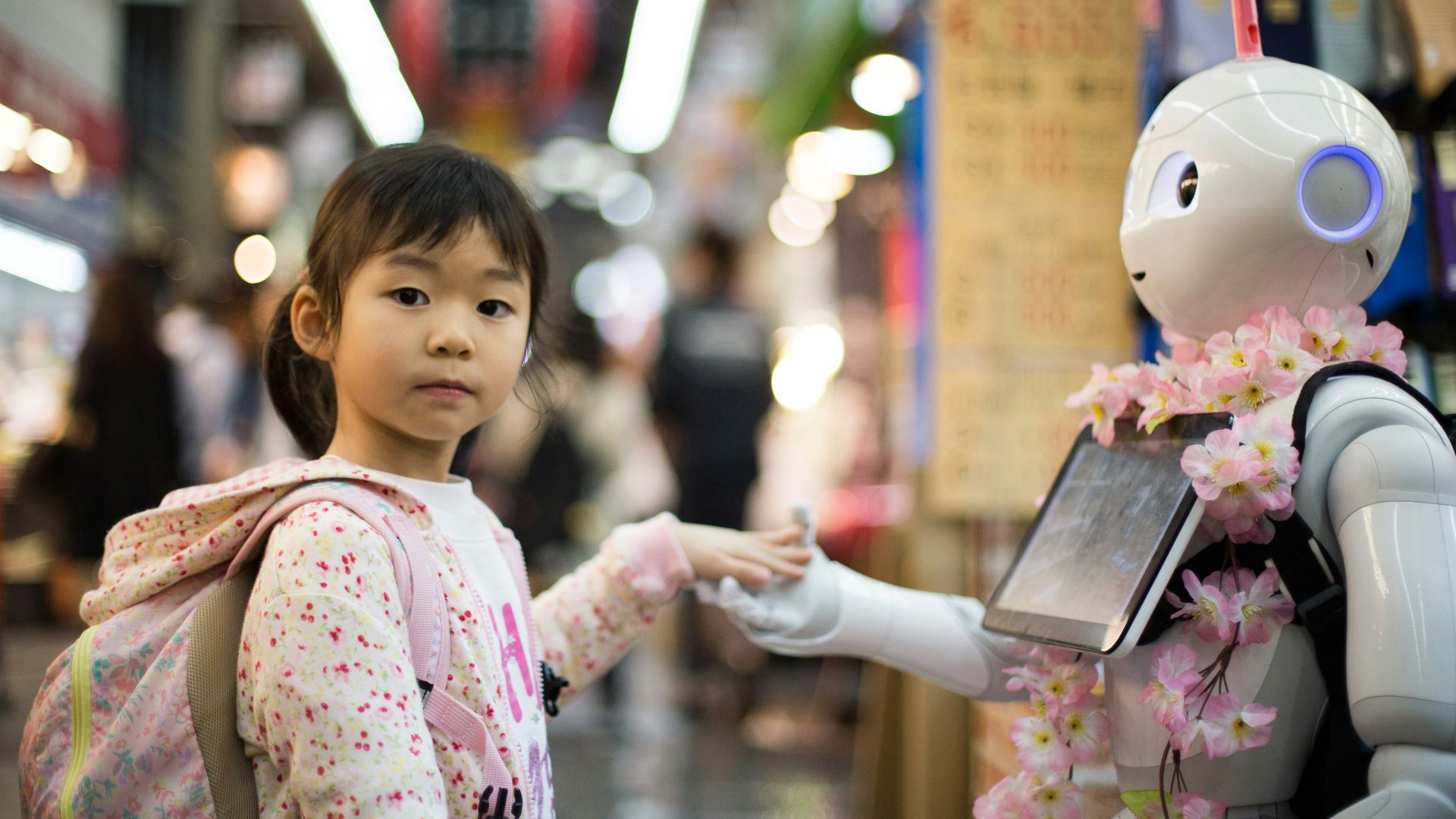 photo of girl laying left hand on white digital robot